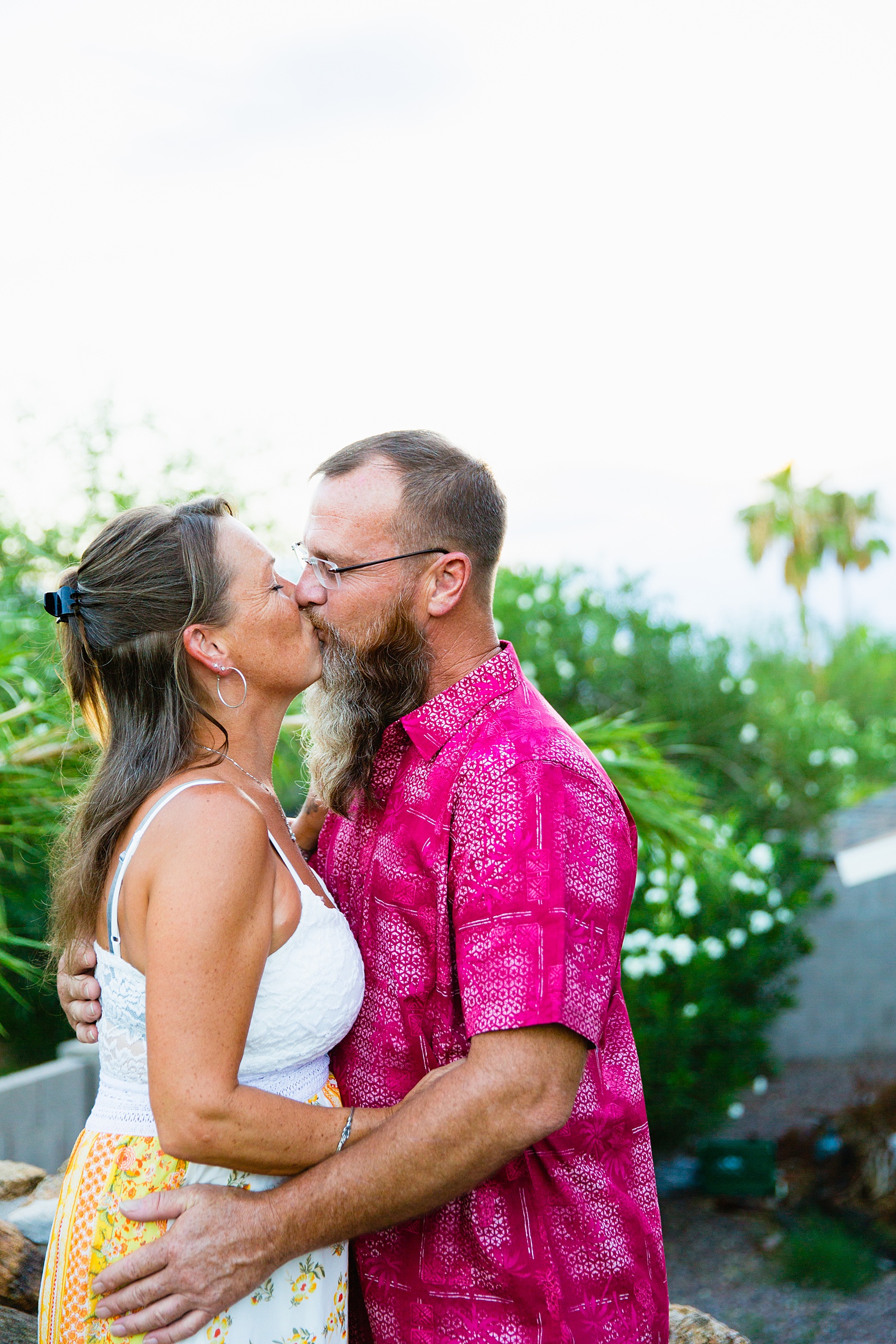 Couple share a kiss during their Backyard engagement session by Phoenix wedding photographer PMA Photography.