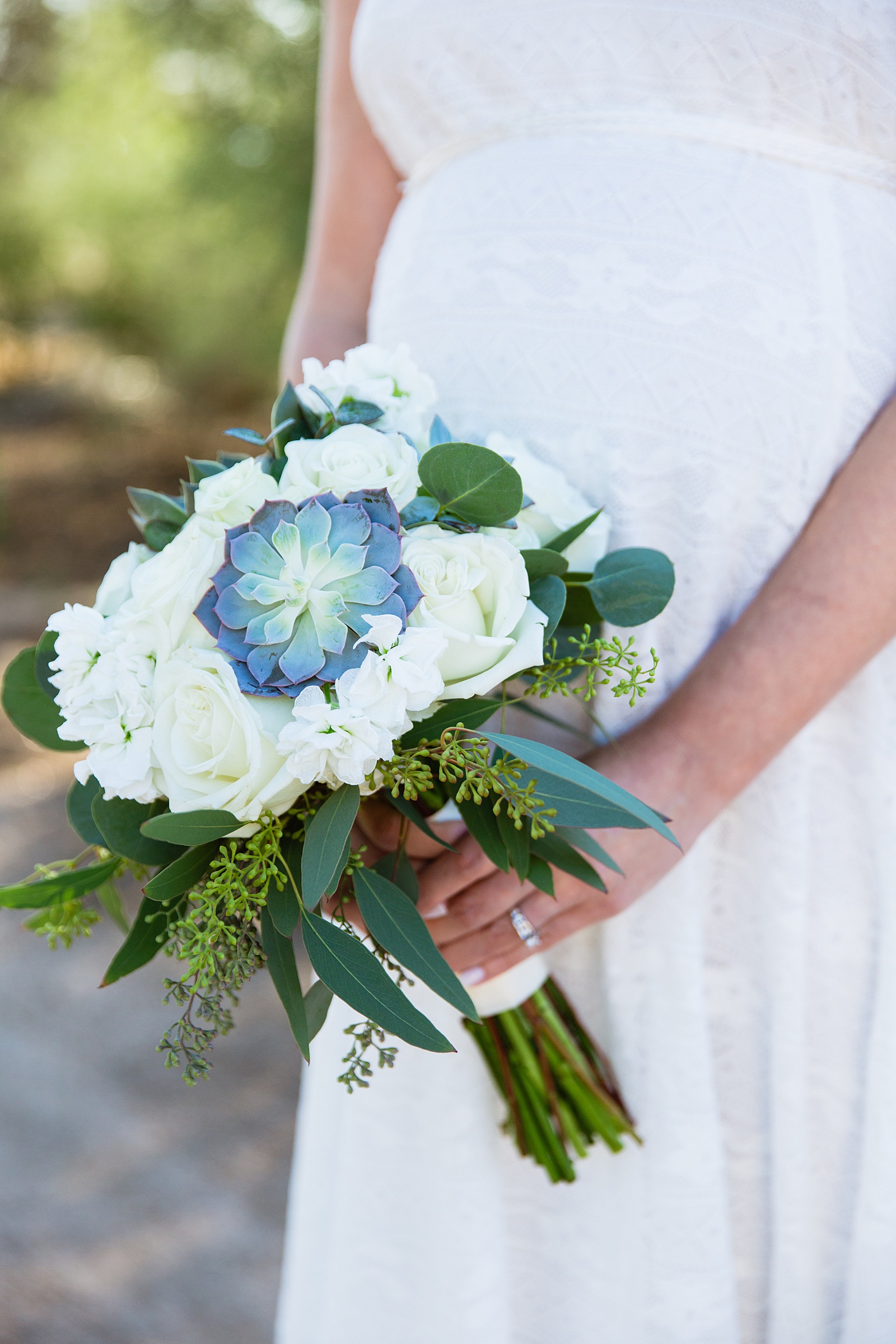 Bride's blue succulent, eucalyptus, and white floral bouquet by PMA Photography.