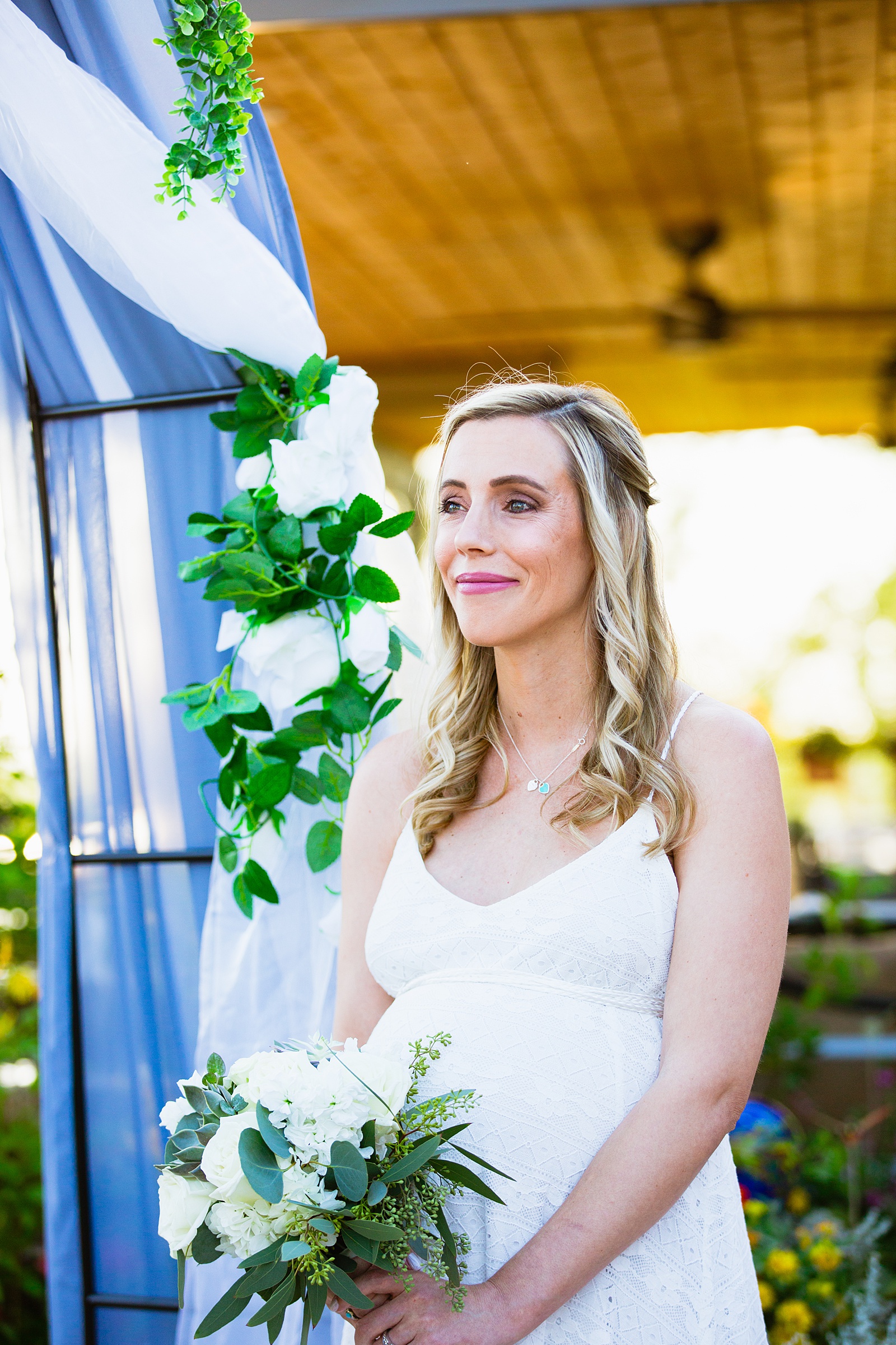 Bride looking at her groom during their wedding ceremony at a backyard by Scottsdale wedding photographer PMA Photography.