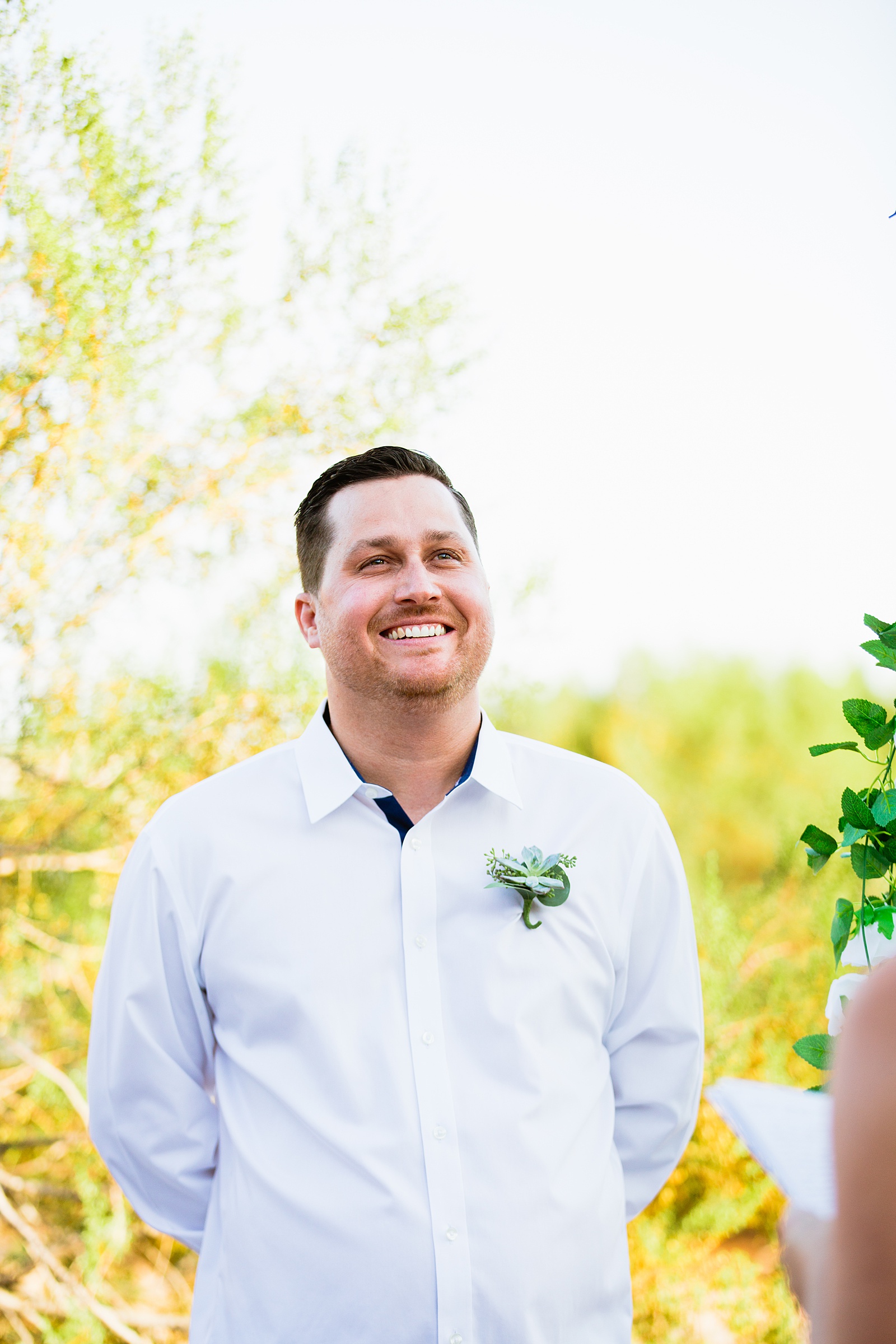 Groom looking at his bride during their wedding ceremony at a backyard by Scottsdale wedding photographer PMA Photography.