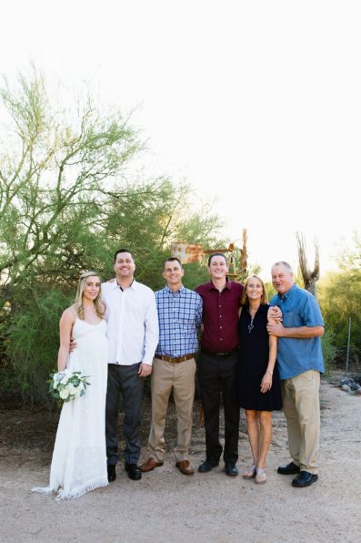 Bride and groom pose with their family members during their desert backyard elopement by Scottsdale wedding photographer PMA Photography.