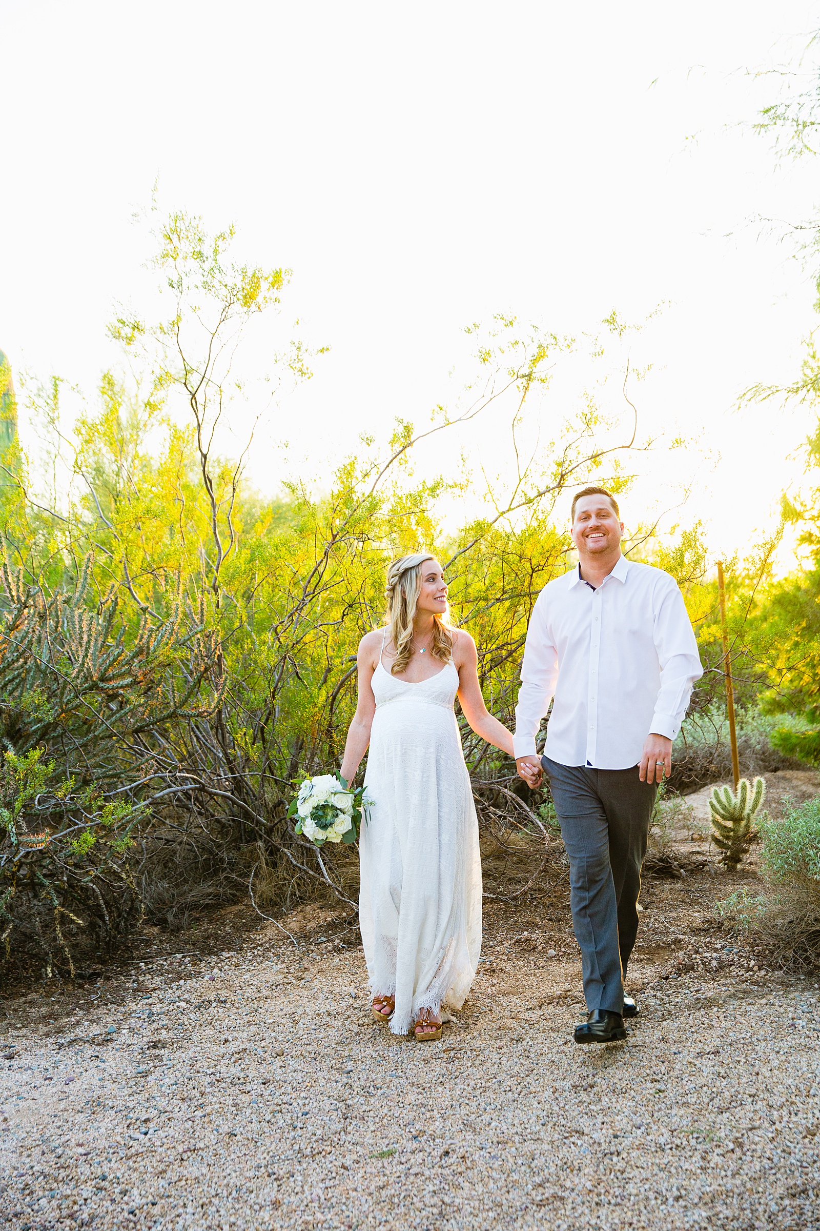 Bride and Groom walking together during their desert backyard elopement in Scottsdale by Arizona wedding photographer PMA Photography.