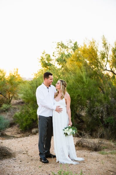 Pregnant bride and Groom share an intimate moment during their desert backyard elopement in Scottsdale by Arizona wedding photographer PMA Photography.