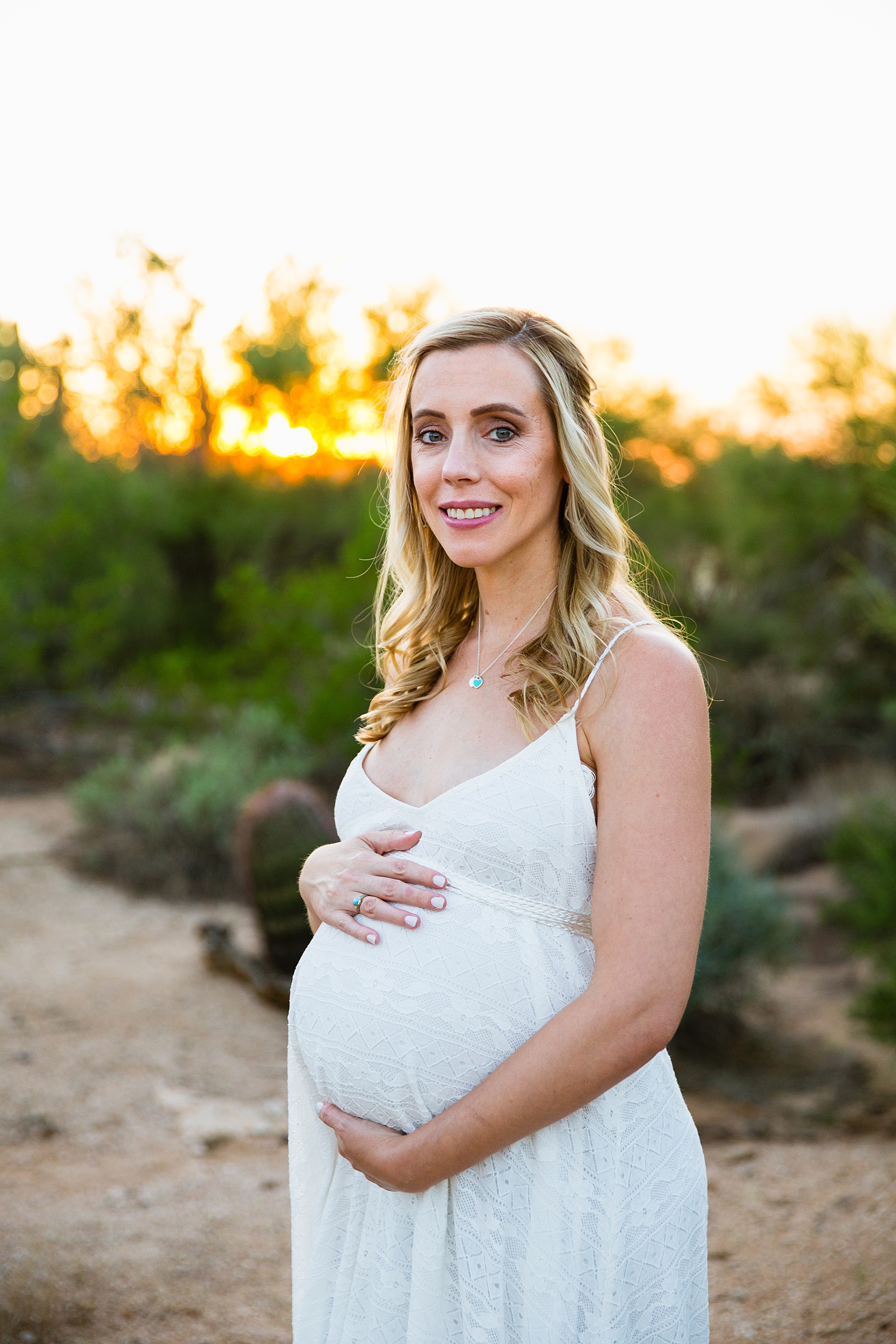 Pregnant bride poses during her desert backyard elopement in Scottsdale by Arizona wedding photographer PMA Photography.