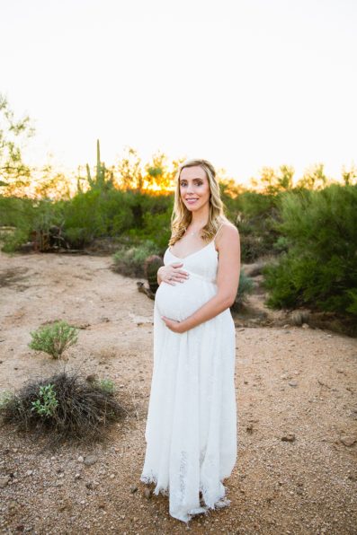 Pregnant bride poses during her desert backyard elopement in Scottsdale by Arizona wedding photographer PMA Photography.