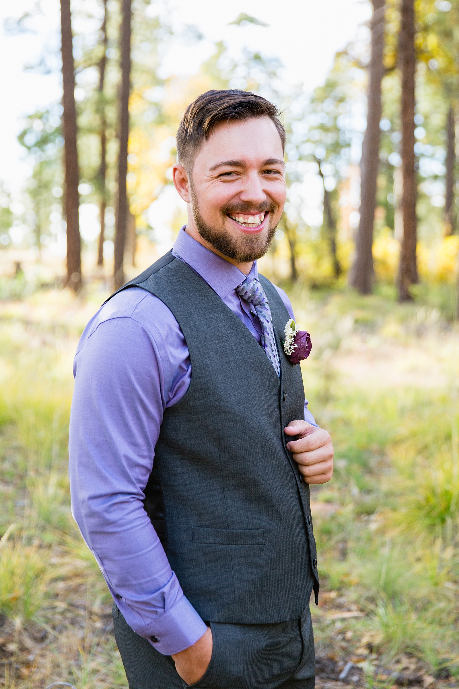 Groom laughing in his purple and grey suit for his Mogollon Rim elopement by PMA Photography.