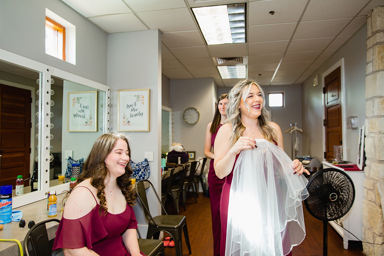 Candid photograph of bridesmaids as the bride getting ready for her wedding by Phoenix wedding photographers PMA Photographer