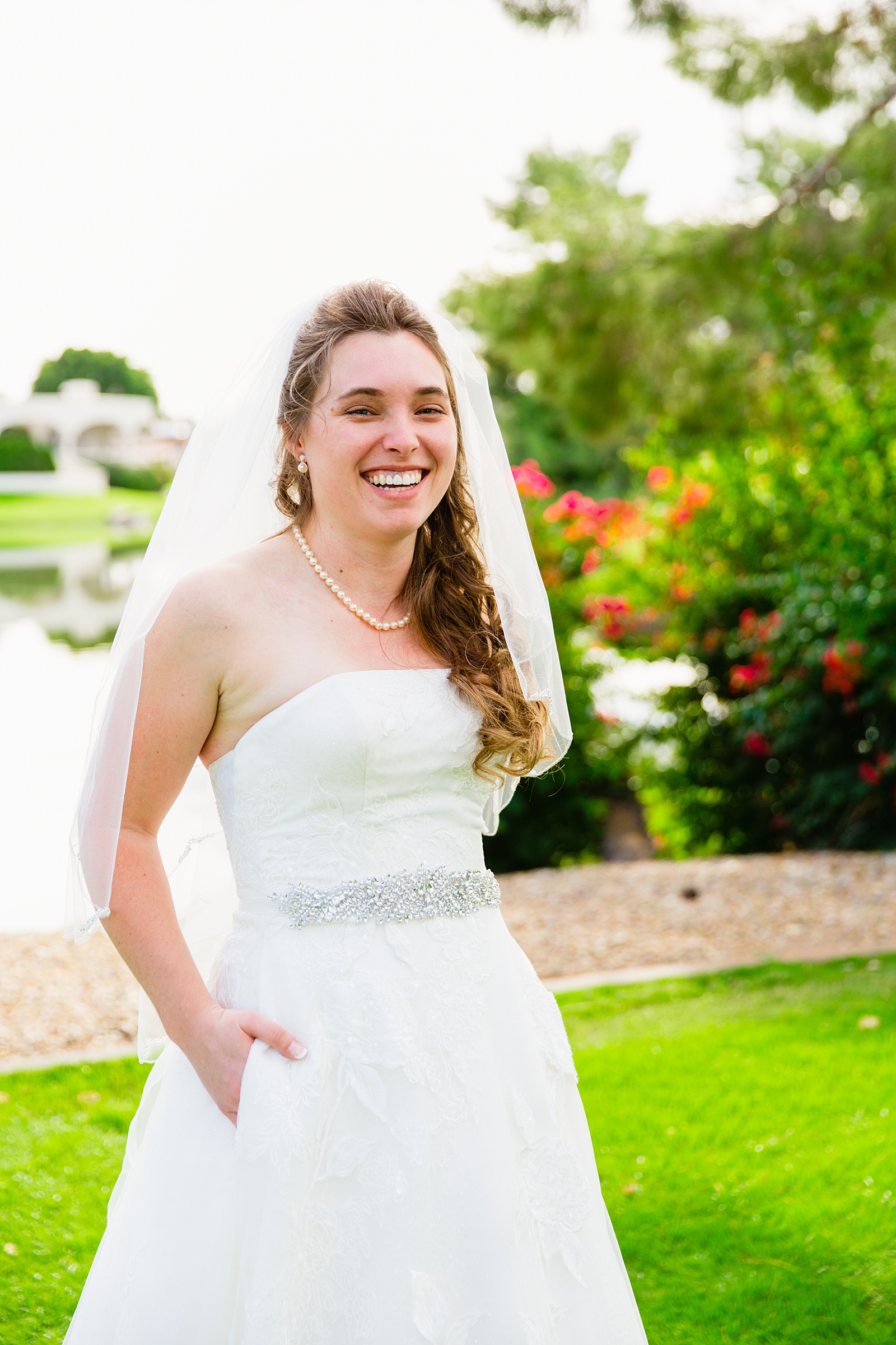 Bride laughing showing off the pockets of her wedding dress for her Ocotillo Oasis wedding by PMA Photography.