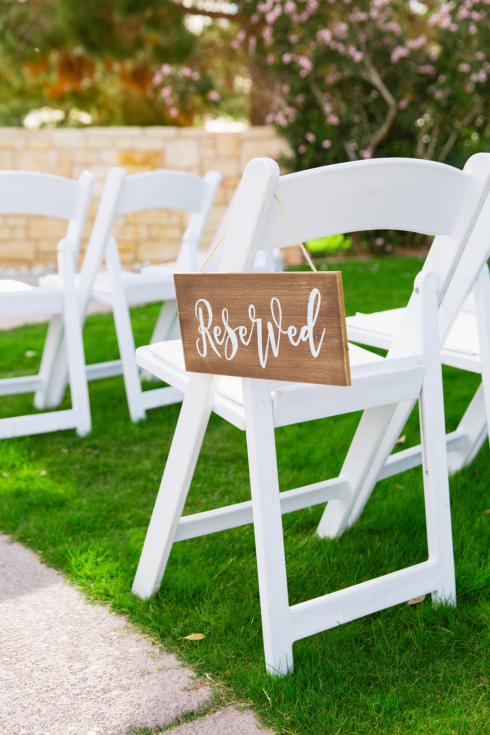 Wooden reserved sign on a ceremony chair by Phoenix wedding photographers PMA Photography.
