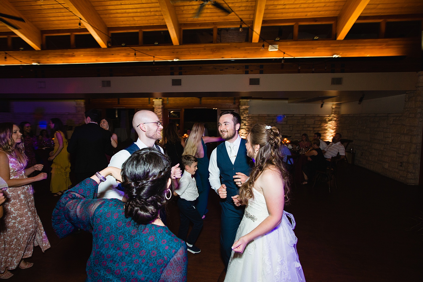 Bride and Groom dancing with guests at their Ocotillo Oasis wedding reception by Arizona wedding photographer PMA Photography
