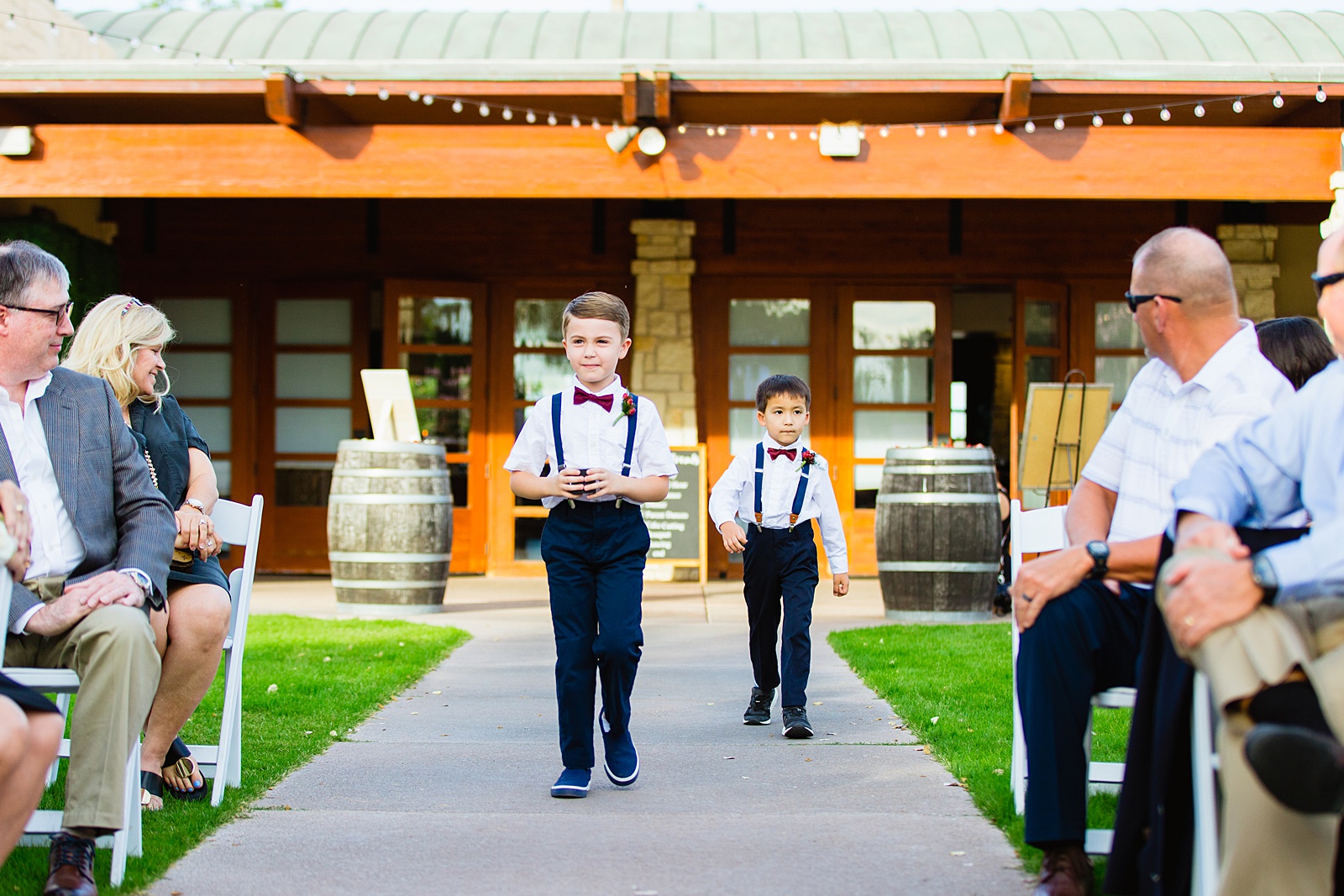 Ring bearers walking down aisle during Ocotillo Oasis wedding ceremony by Phoenix wedding photographer PMA Photography.