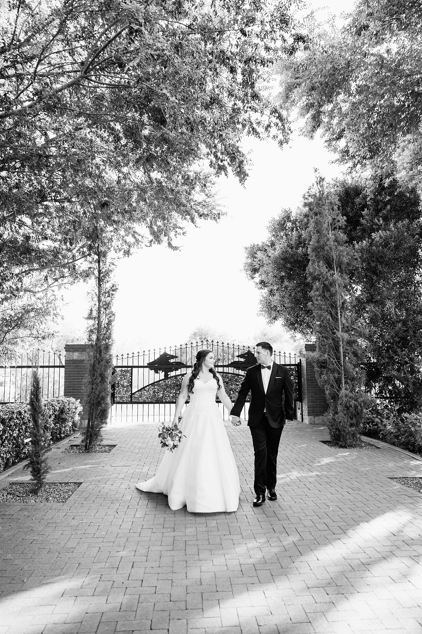 Bride and groom walking together during their Stonebridge Manor wedding by Arizona wedding photographer PMA Photography.