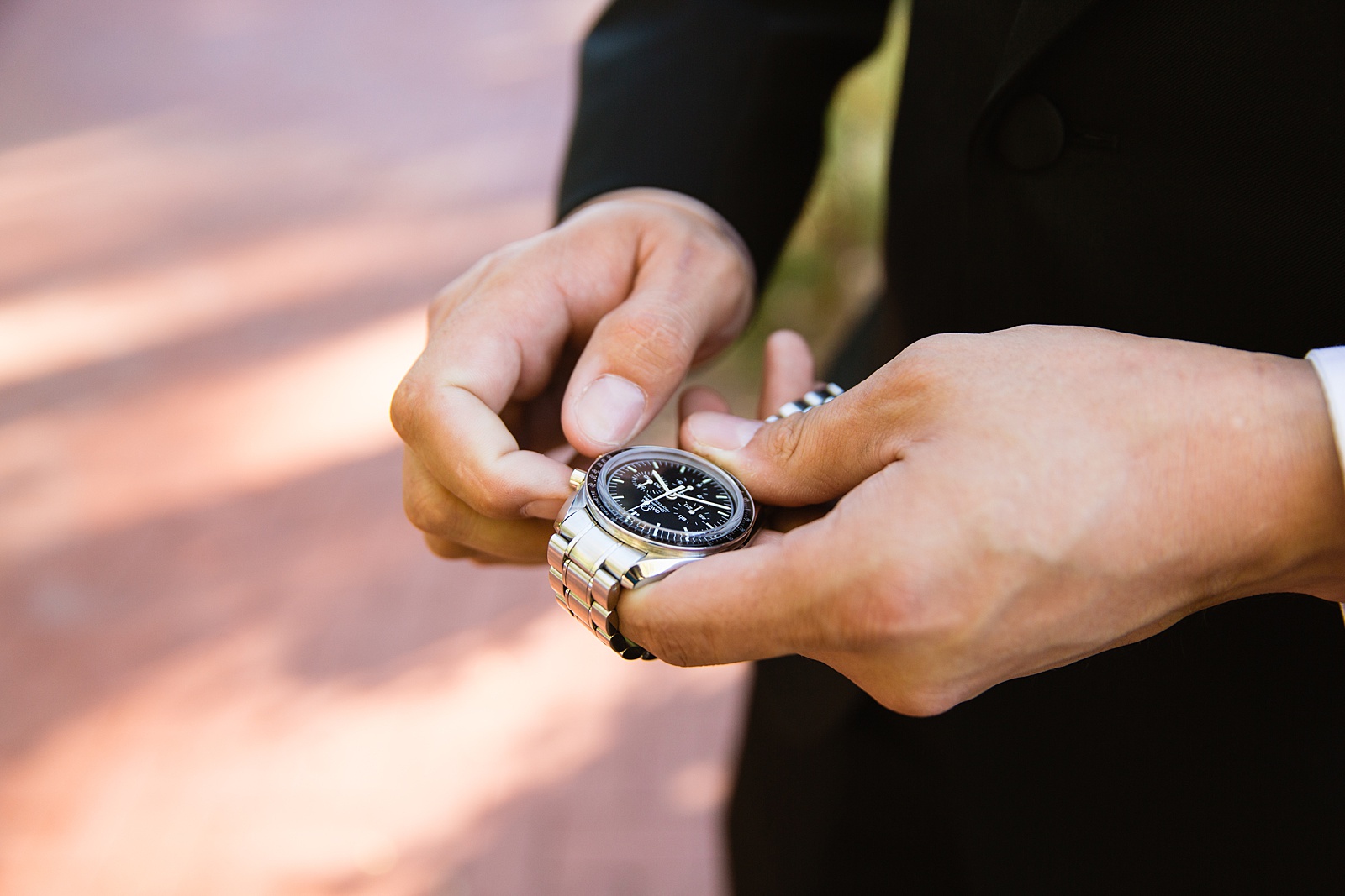 Groom winding his silver omega watch on his wedding day by Mesa wedding photographer PMA Photography.