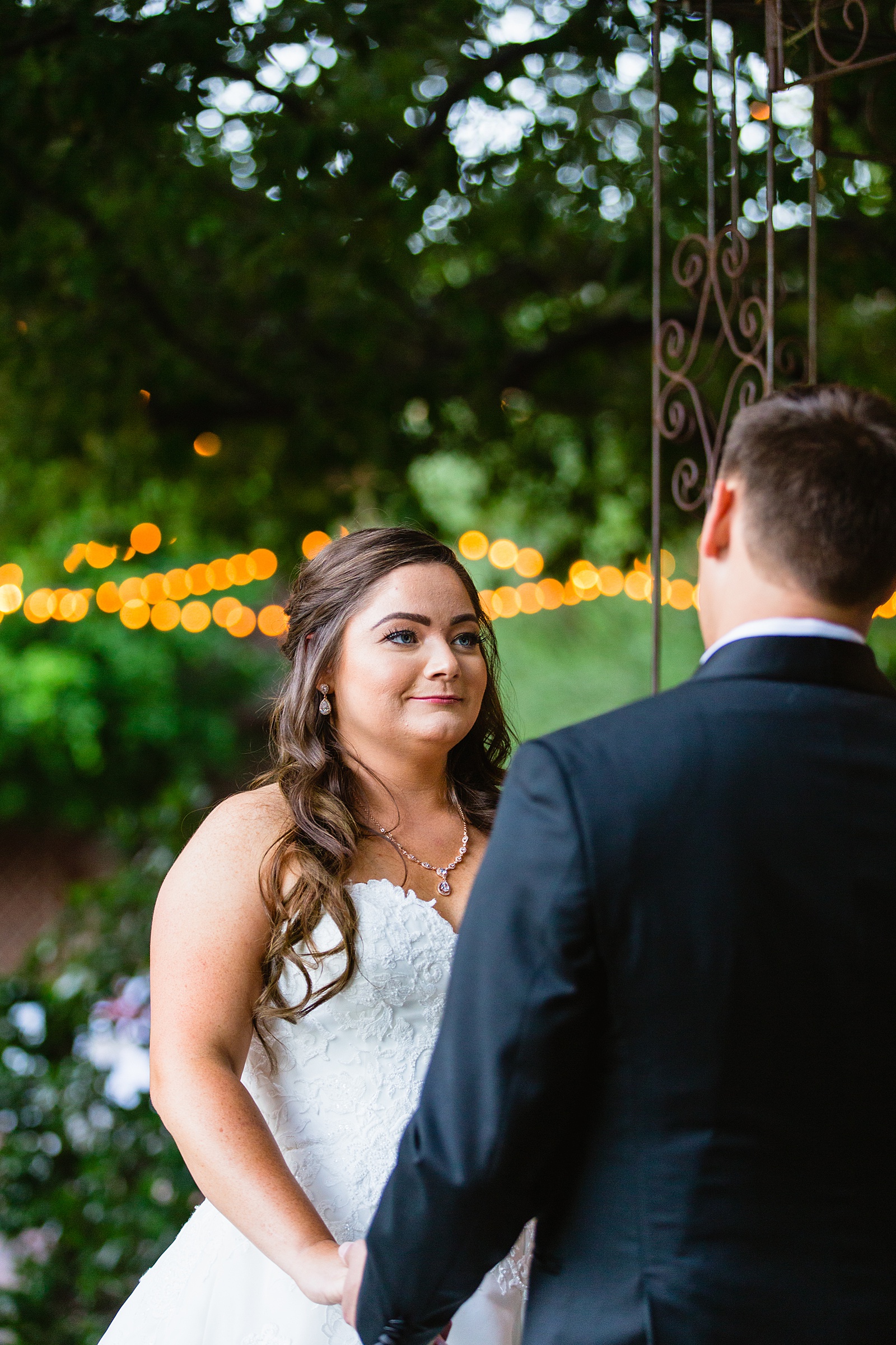Bride looking at her groom during their wedding ceremony at Stonebridge Manor by Mesa wedding photographer PMA Photography.