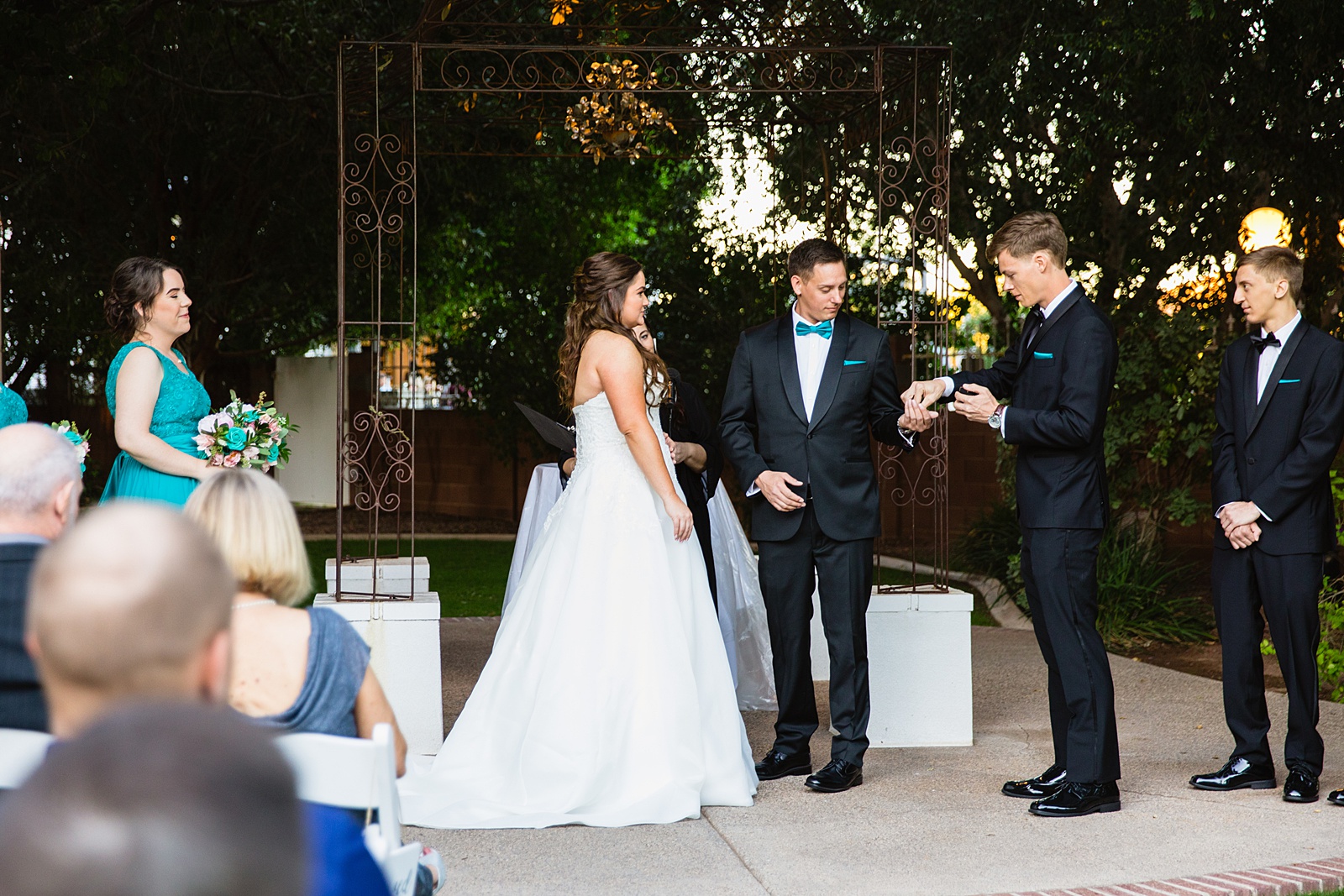 Best man giving the rings to the groom during the wedding ceremony at Stonebridge Manor by Arizona wedding photographer PMA Photography.