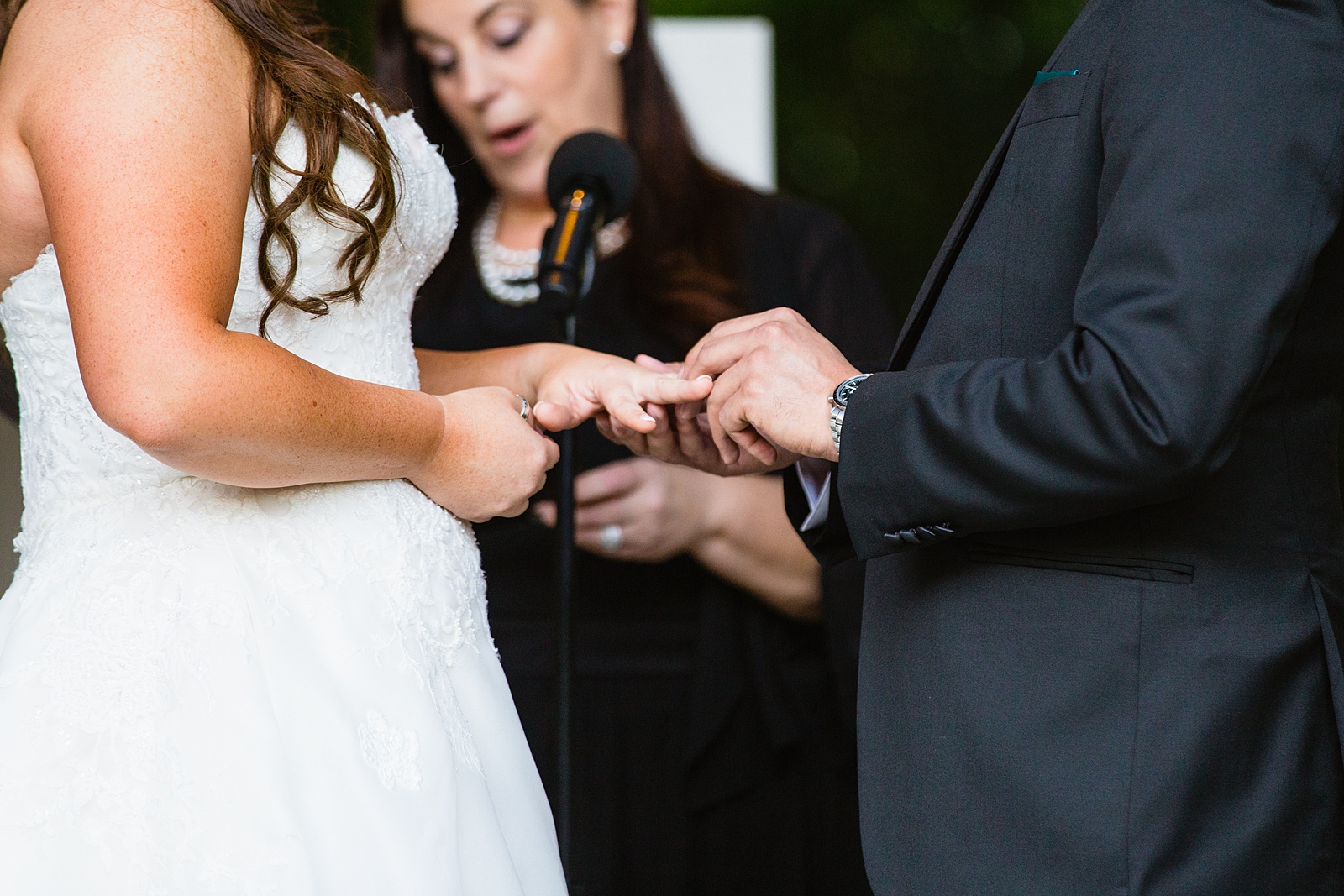 Bride and groom exchange rings during their wedding ceremony at Stonebridge Manor by Phoenix wedding photographer PMA Photography.