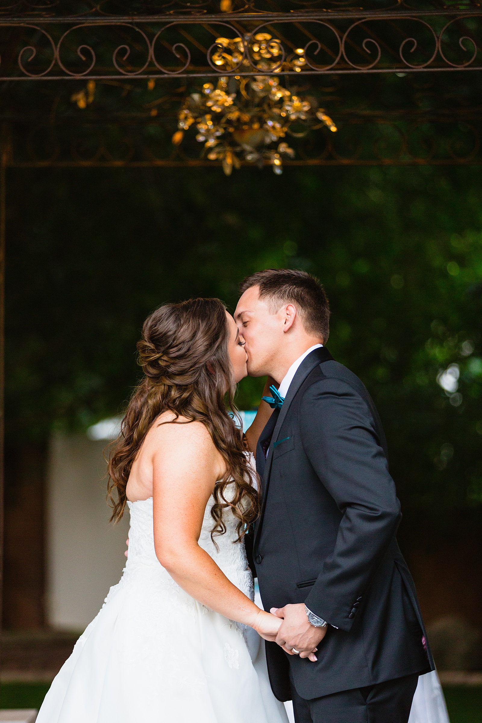 Bride and groom share their first kiss during their wedding ceremony at Stonebridge Manor by Arizona wedding photographer PMA Photography.