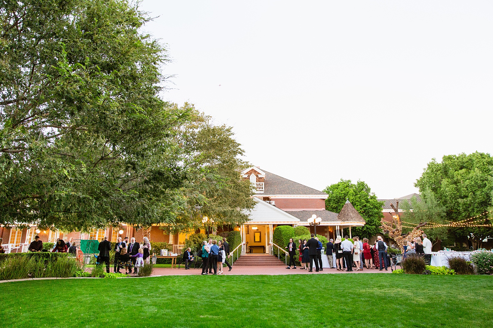 Guests enjoying cocktail hour on the patio of the outdoor wedding venue Stonebridge Manor by Mesa wedding photographer PMA Photography.
