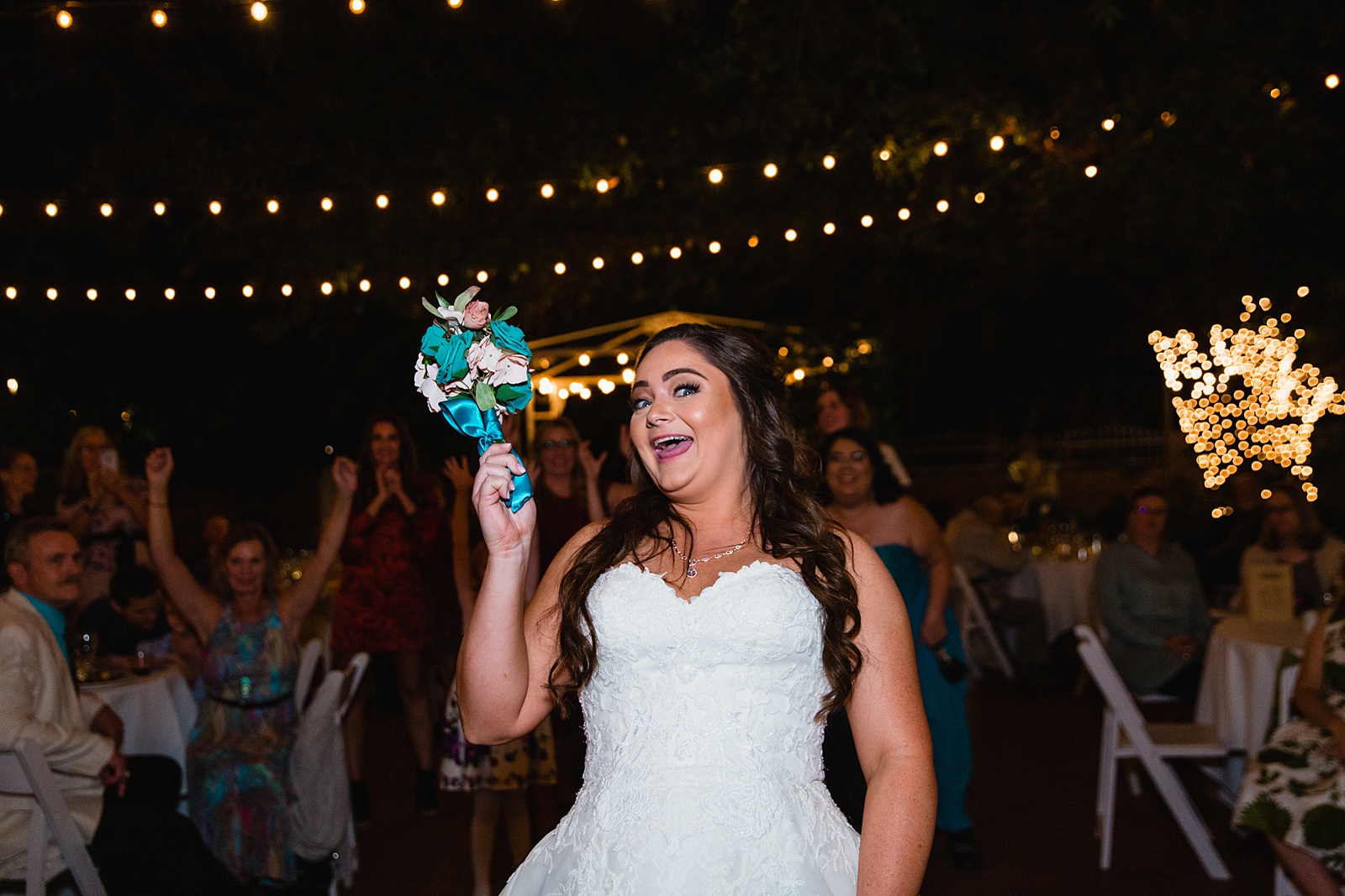 Bouquet toss at Stonebridge Manor wedding reception by Mesa wedding photographer PMA Photography.
