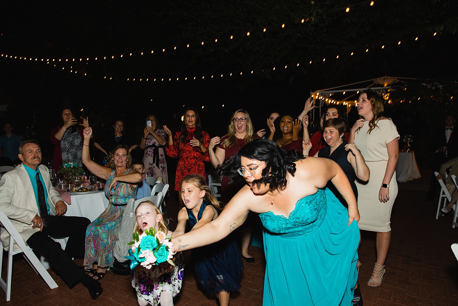 Bouquet toss at Stonebridge Manor wedding reception by Mesa wedding photographer PMA Photography.