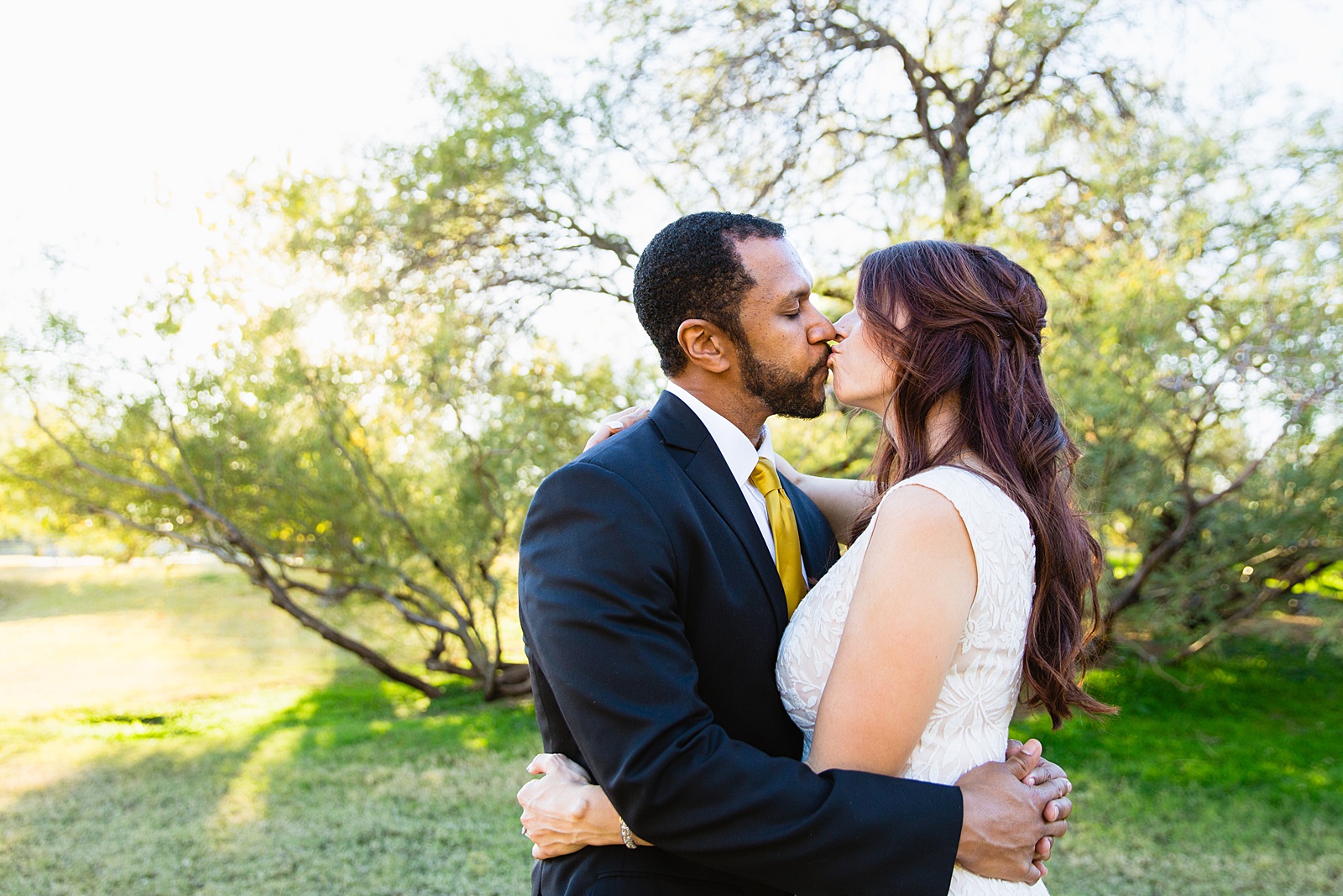 Bride and groom share a kiss during their Backyard Micro wedding by Arizona wedding photographer PMA Photography.