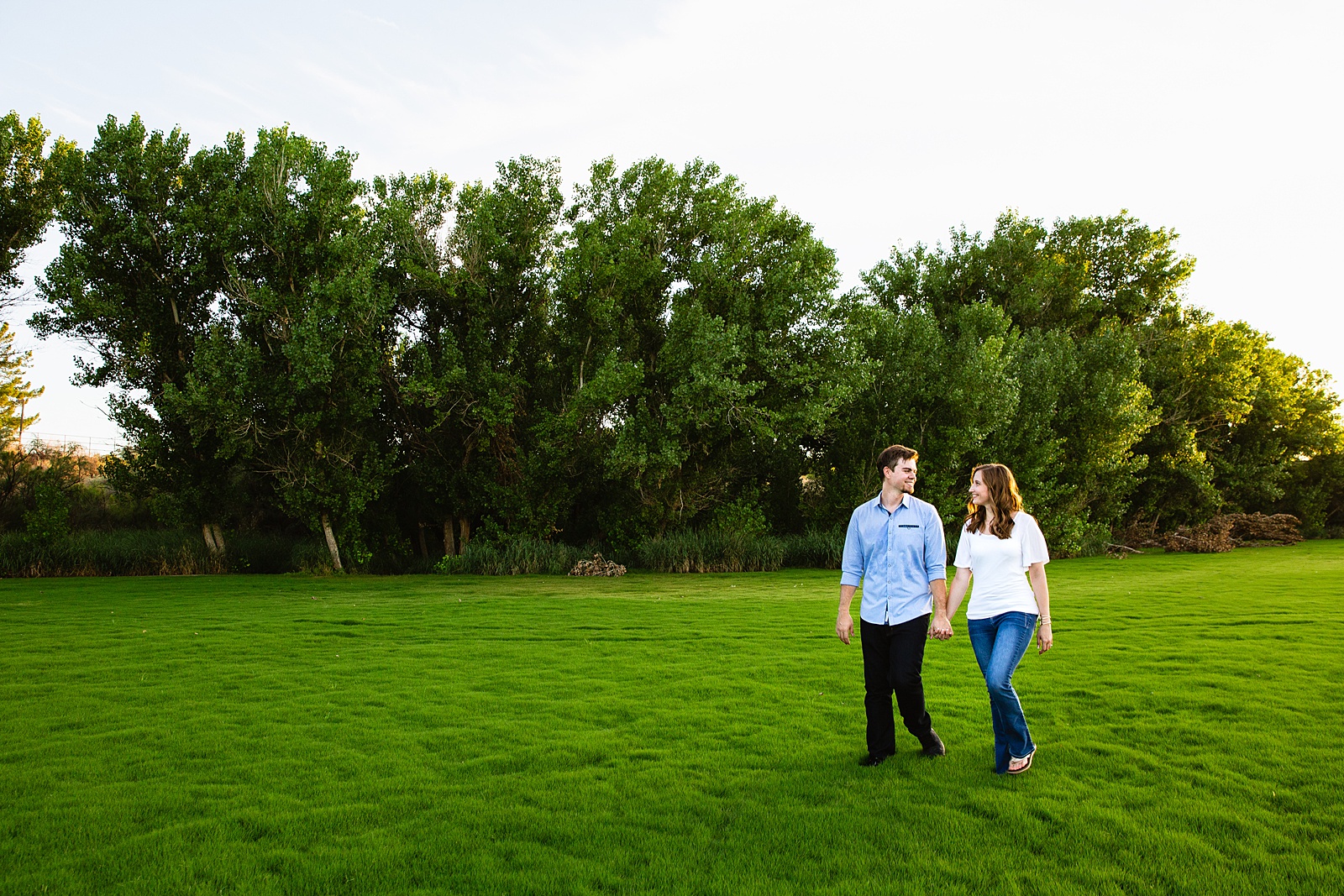 Couple walking together during their Gilbert engagement session by Arizona engagement photographer PMA Photography.