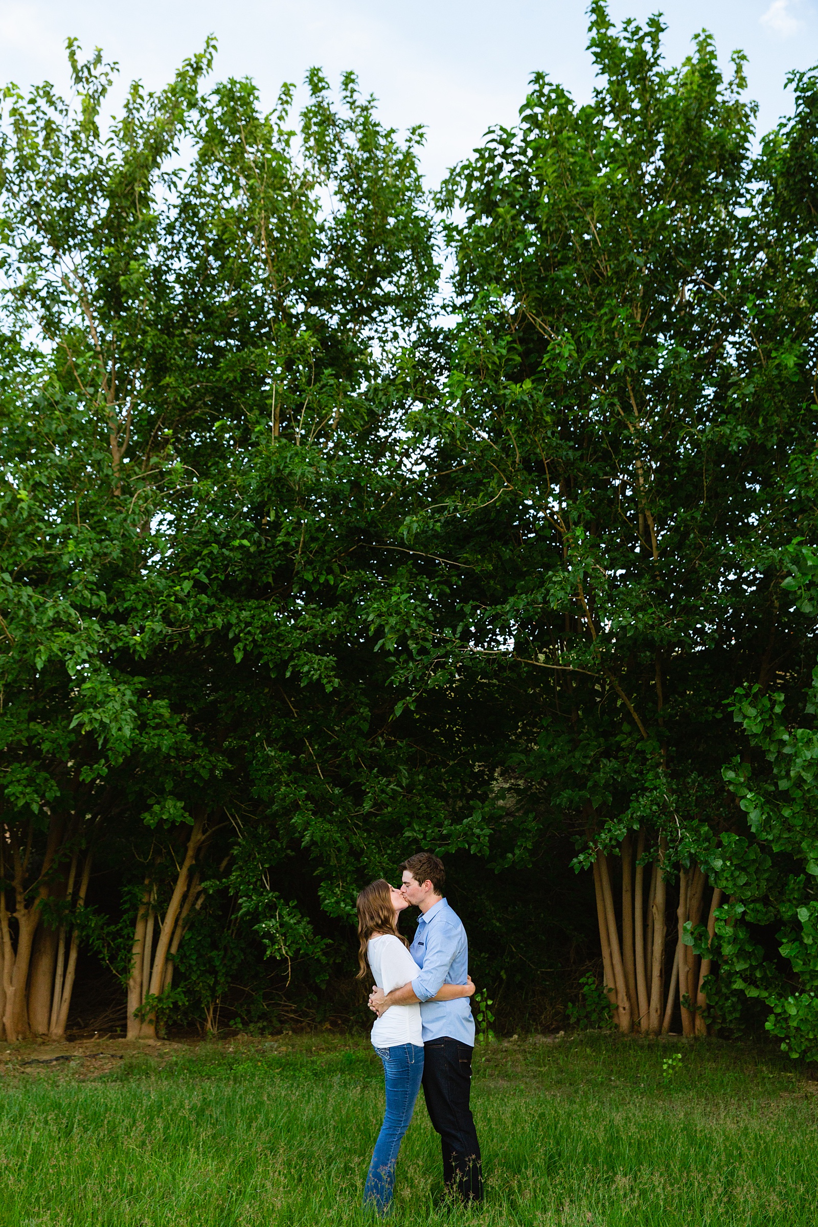 Couple share a kiss during their Gilbert engagement session by Arizona wedding photographer PMA Photography.