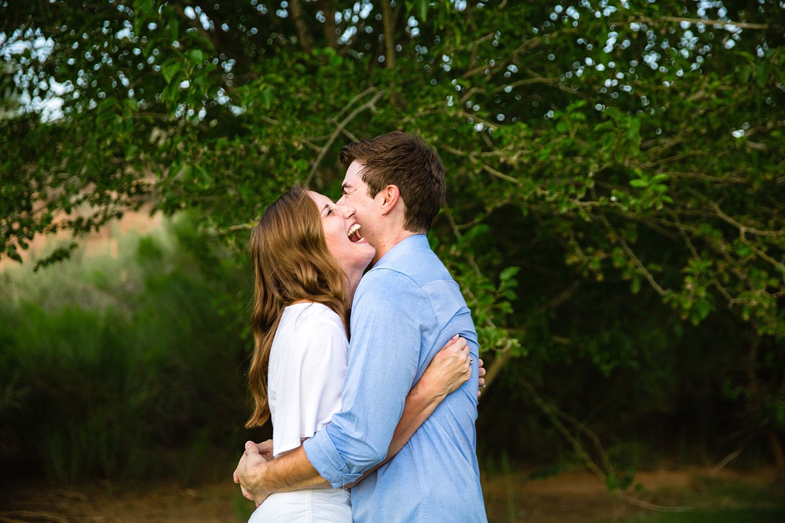 Couple laugh together during their Gilbert engagement session by Arizona engagement photographer PMA Photography.