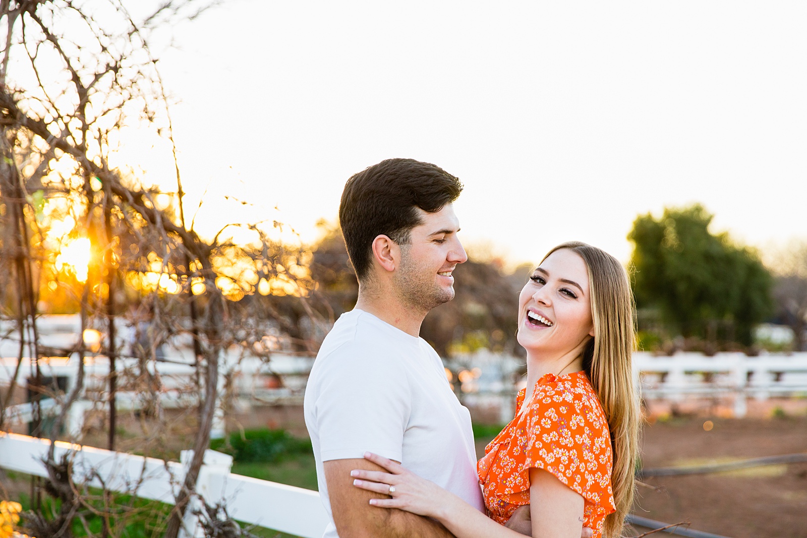 Couple laugh together during their The Farm at Agritopia engagement session by Gilbert engagement photographer PMA Photography.