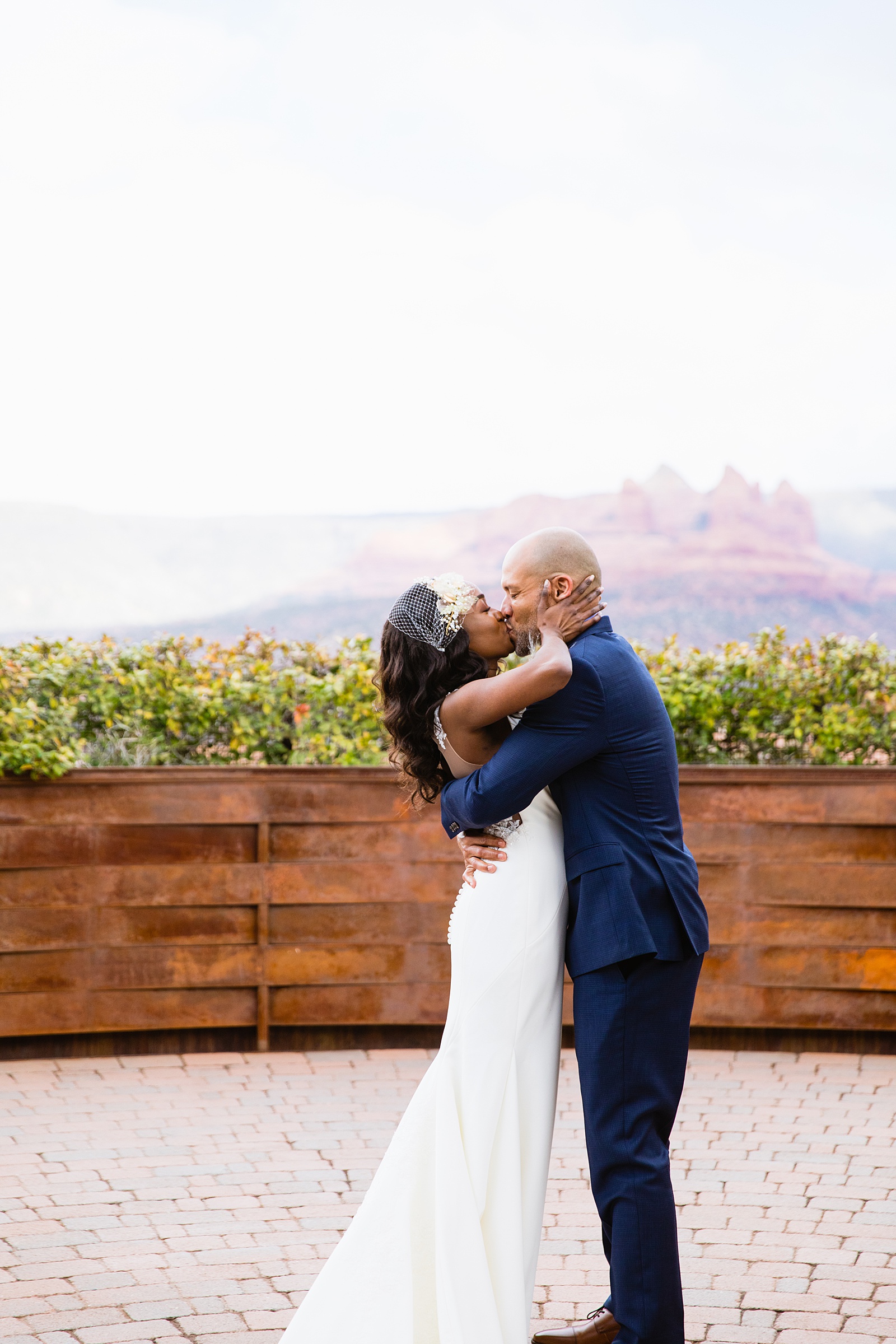Bride and Groom share their first kiss during their wedding ceremony at Agave of Sedona by Arizona wedding photographer PMA Photography.