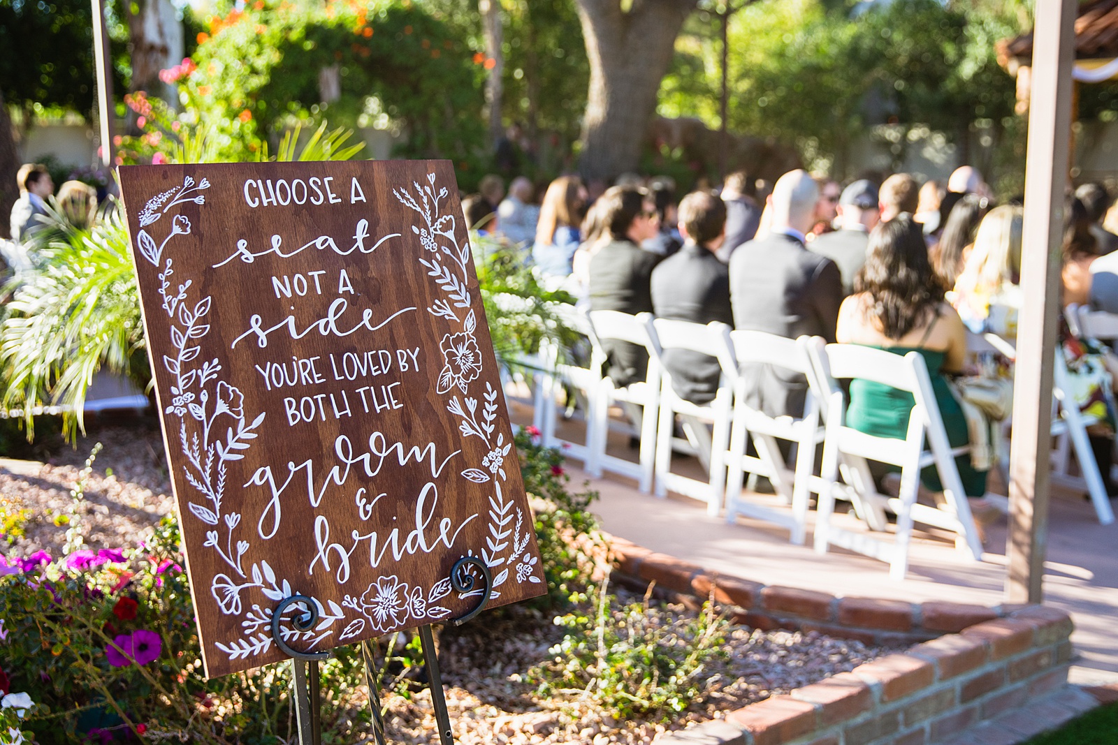 "Choose a seat not a side" rustic garden sign at a wedding ceremony by PMA photography.
