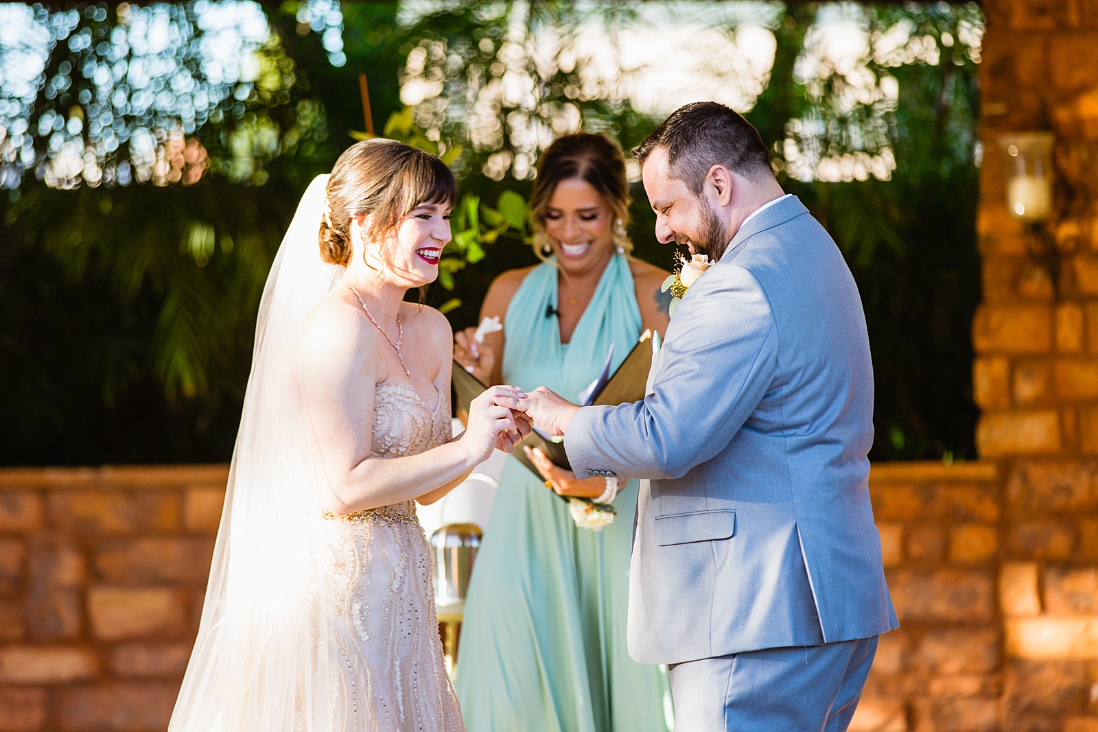 Bride and Groom exchange rings during their wedding ceremony at Bella Rose Estate by Phoenix wedding photographer PMA Photography.