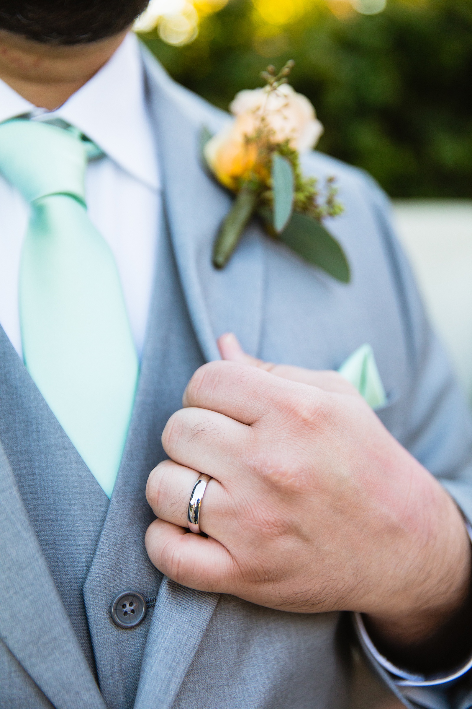 Groom's white gold wedding ring on his light grey suit for his Bella Rose Estate wedding by PMA Photography.