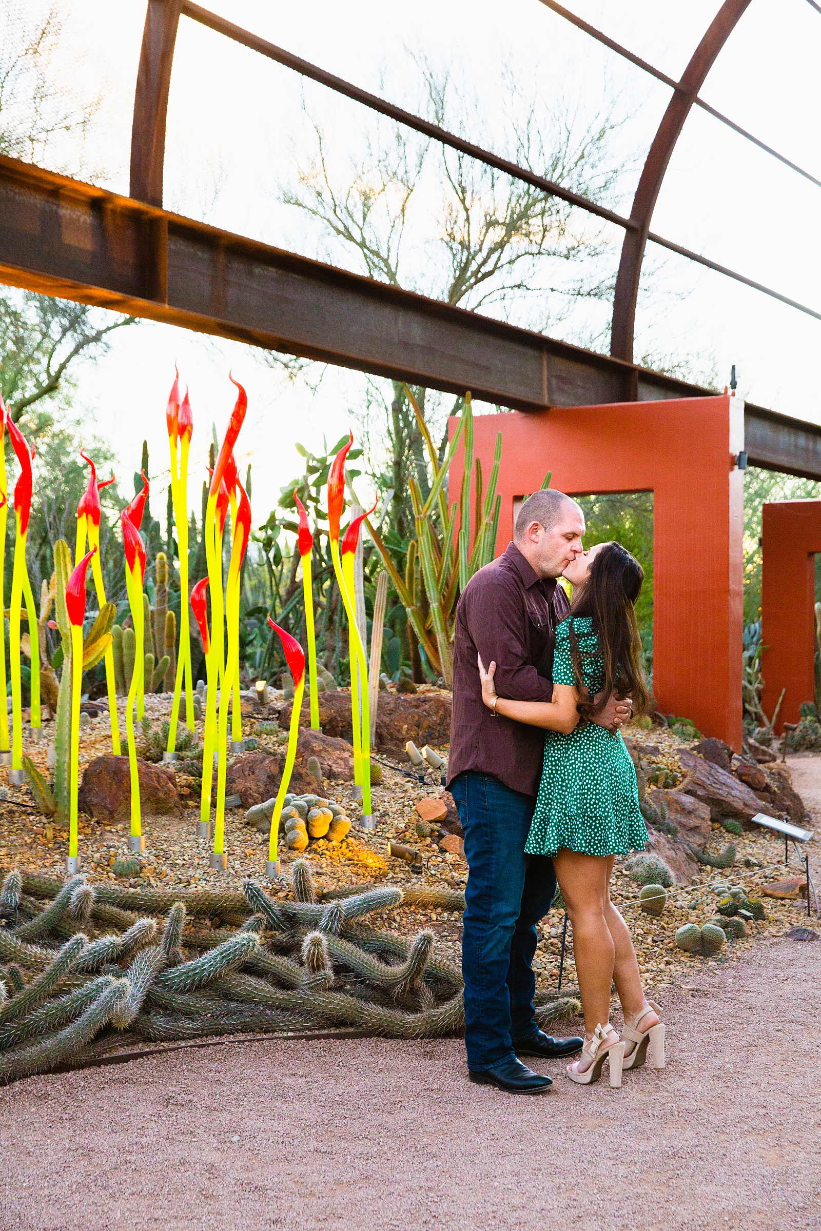 Couple share a kiss during their Desert Botanical Garden engagement session by Phoenix wedding photographer PMA Photography.