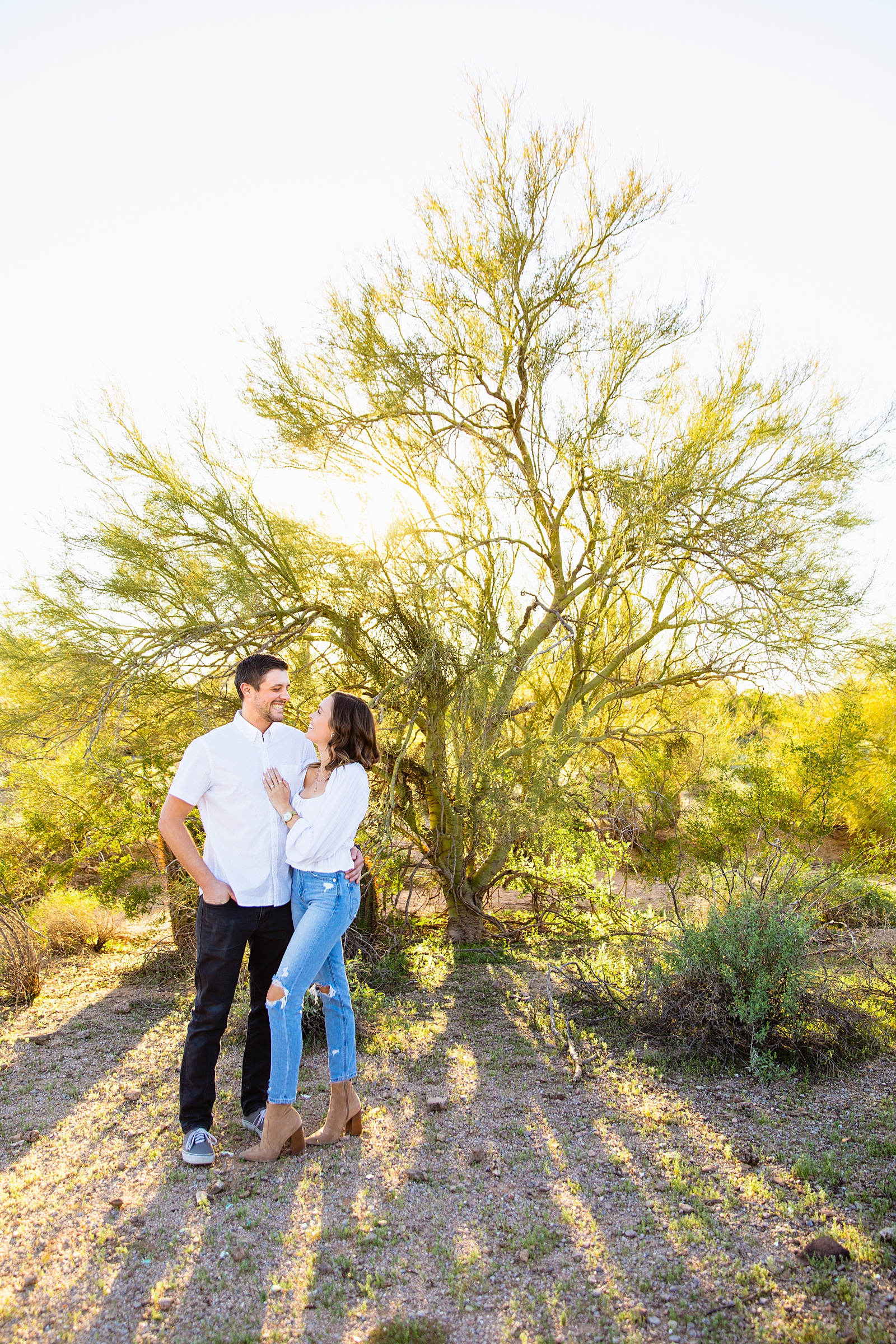 Couple look at each other during their Phoenix engagement session by Arizona wedding photographer PMA Photography.