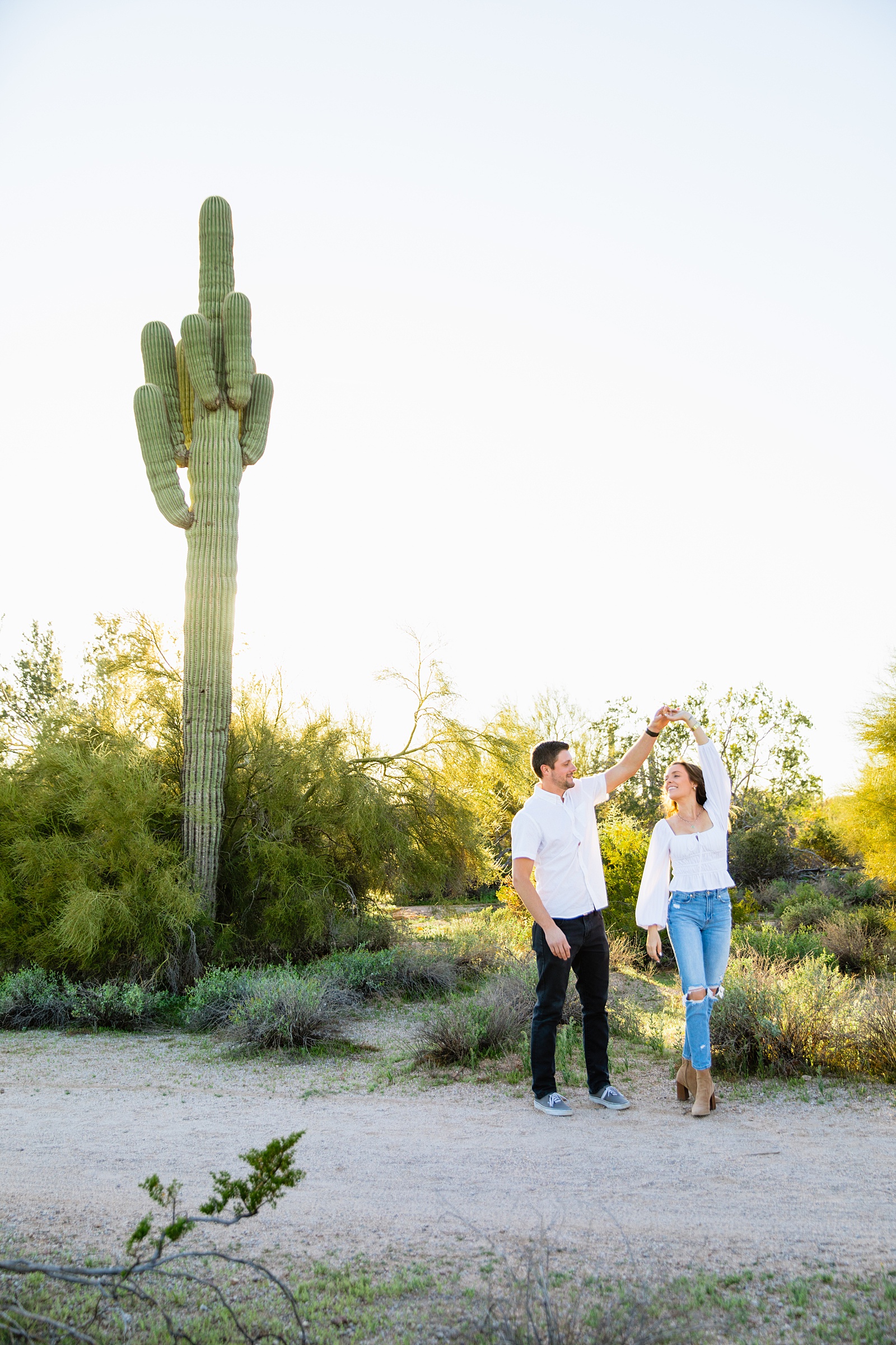 Couple having fun together during their desert engagement session by Phoenix engagement photographer PMA Photography.