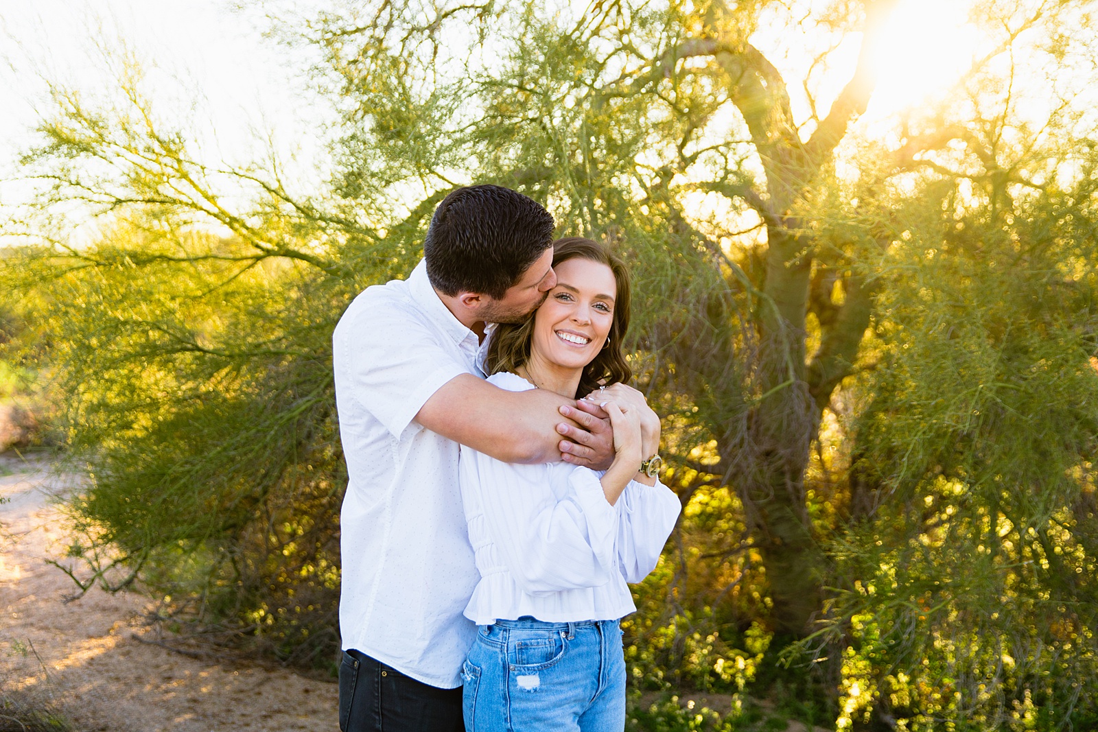 Couple having fun together during their desert engagement session by Phoenix engagement photographer PMA Photography.