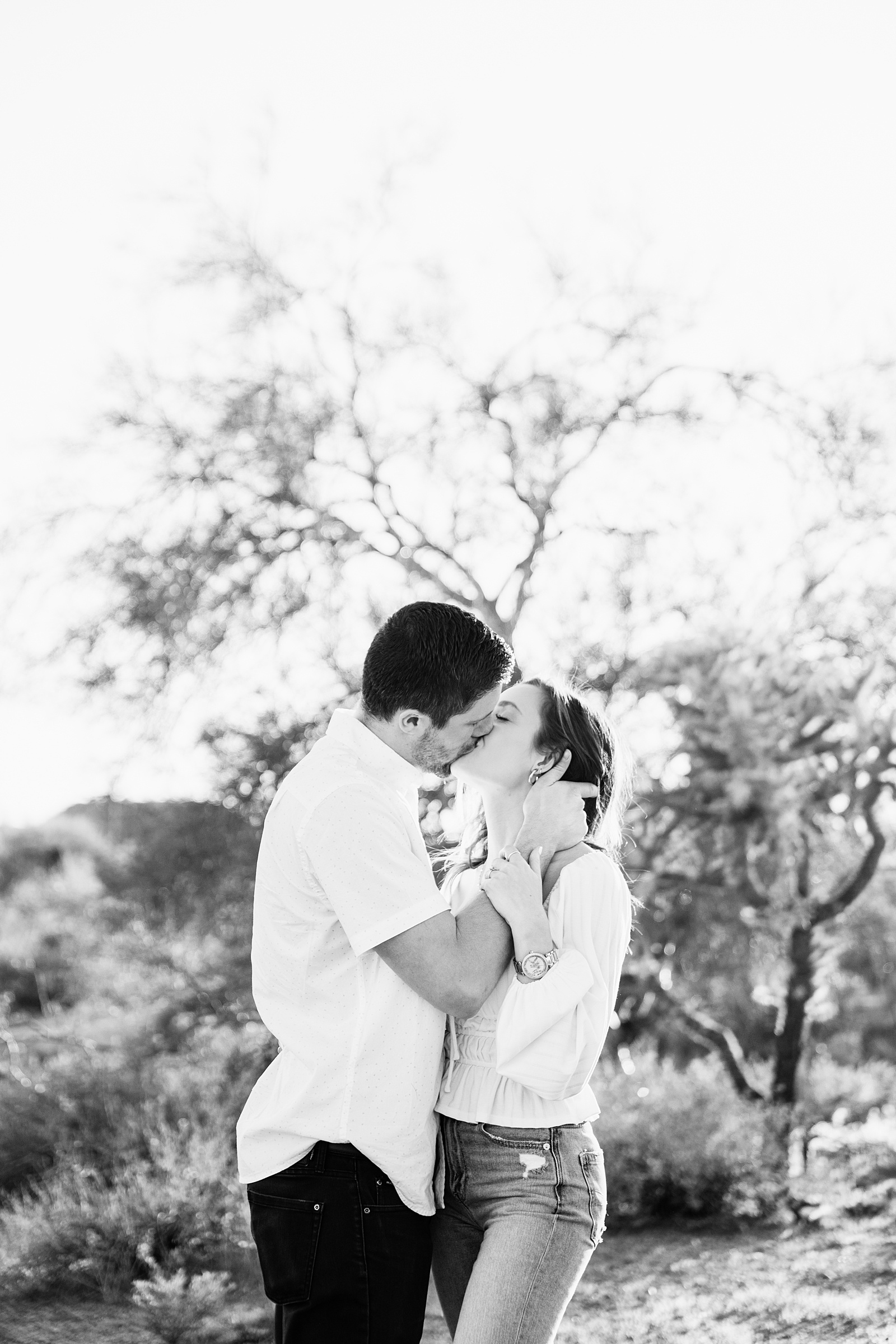 Couple share a kiss during their desert engagement session by Phoenix wedding photographer PMA Photography.