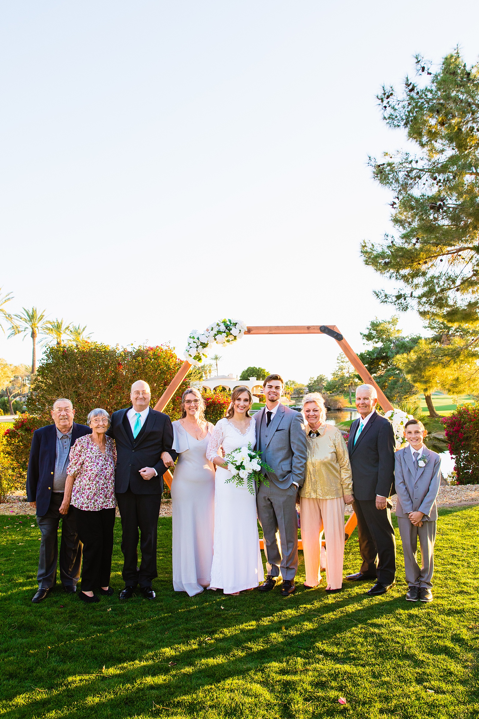 Bride and groom pose with their family during their Ocotillo Oasis wedding by Arizona wedding photographer PMA Photography.