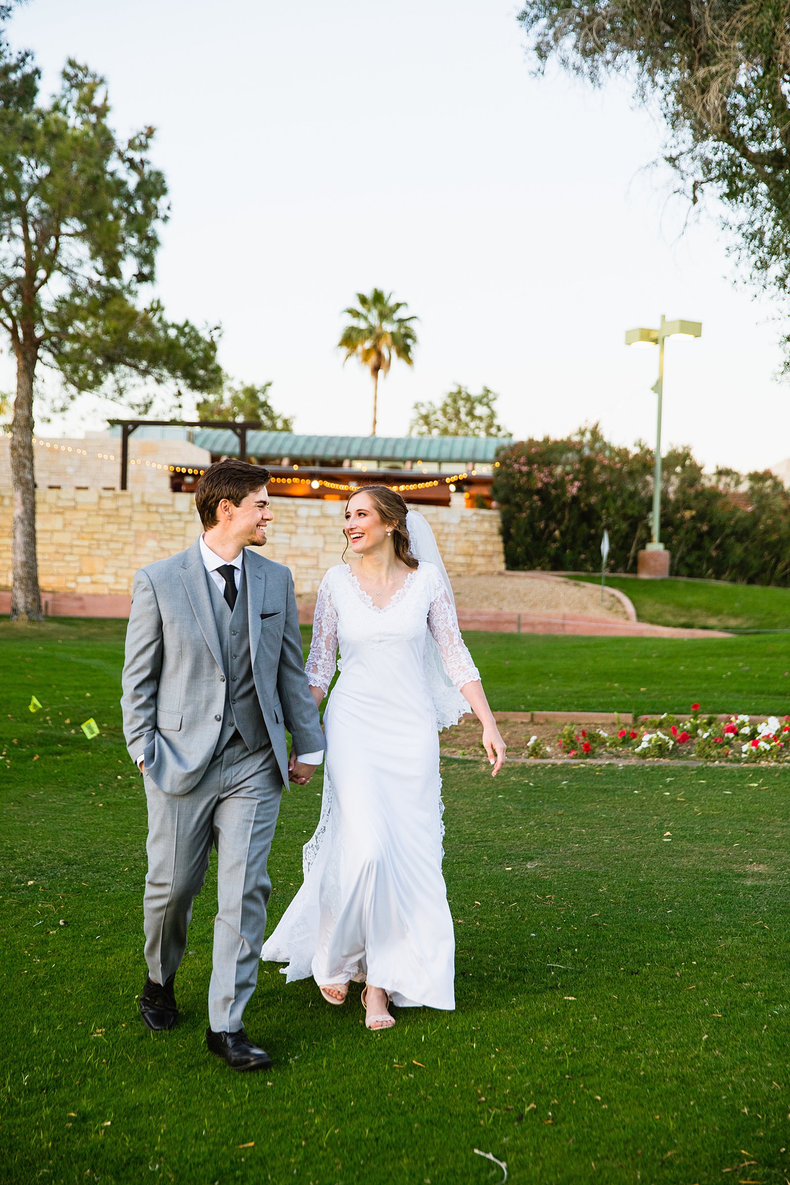 Newlyweds walking together during their Ocotillo Oasis wedding by Arizona wedding photographer PMA Photography.