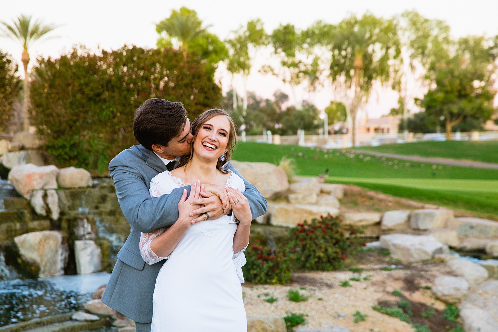 Newlyweds laughing together during their Ocotillo Oasis wedding by Arizona wedding photographer PMA Photography.