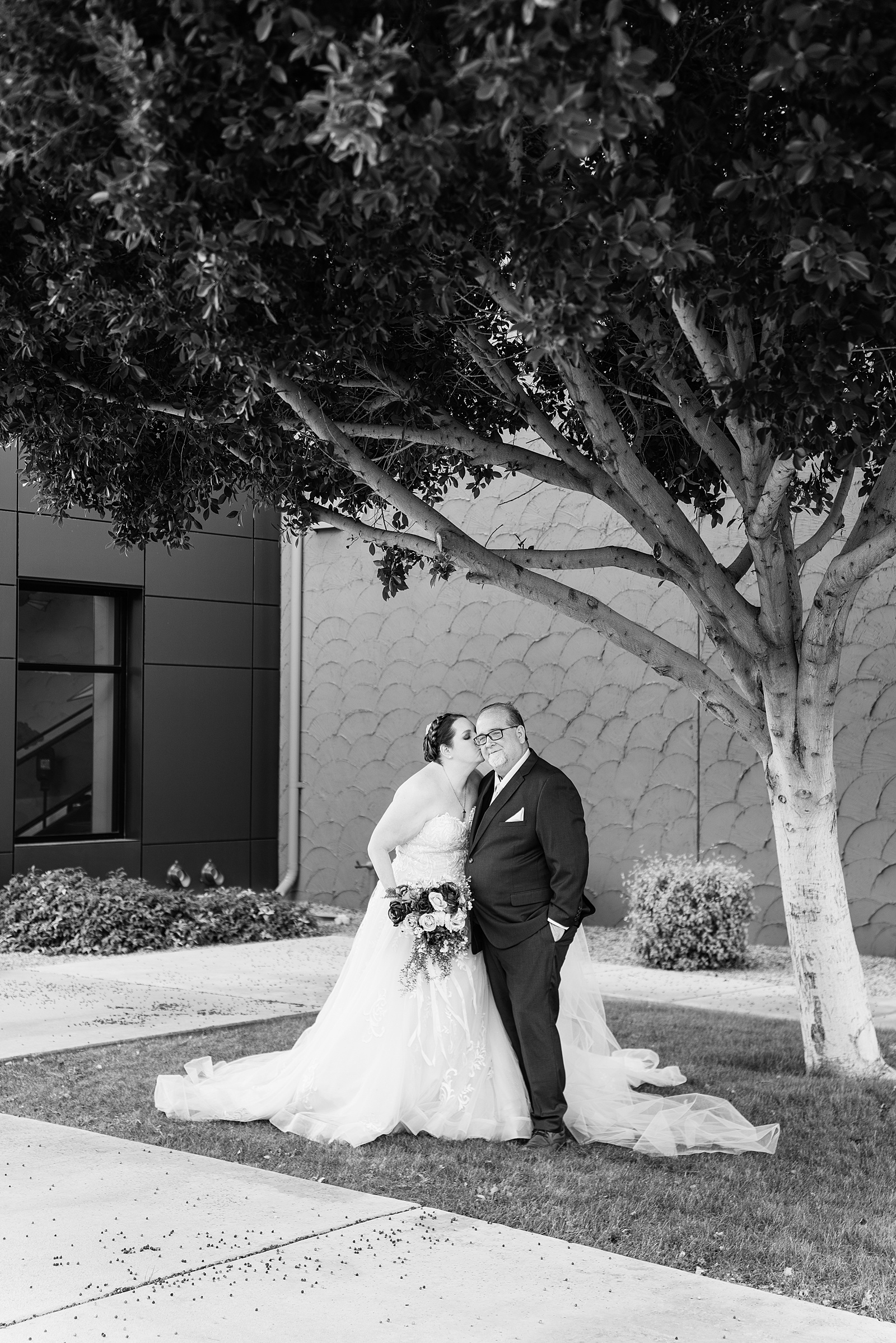 Bride and groom share a kiss during their Sun Valley Church wedding by Tempe wedding photographer PMA Photography.