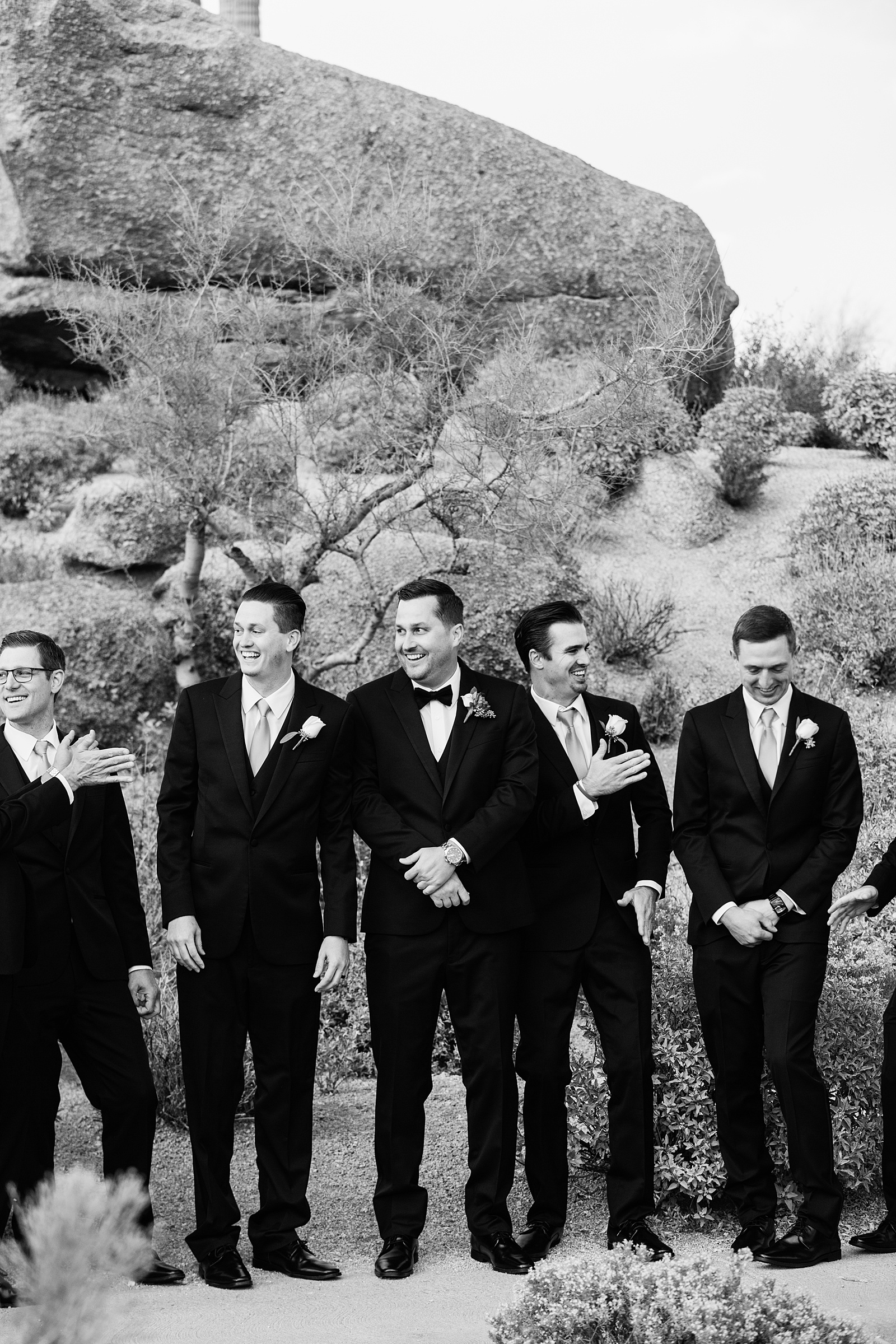 Groom and groomsmen laughing together at Troon North wedding by Scottsdale wedding photographer PMA Photography.