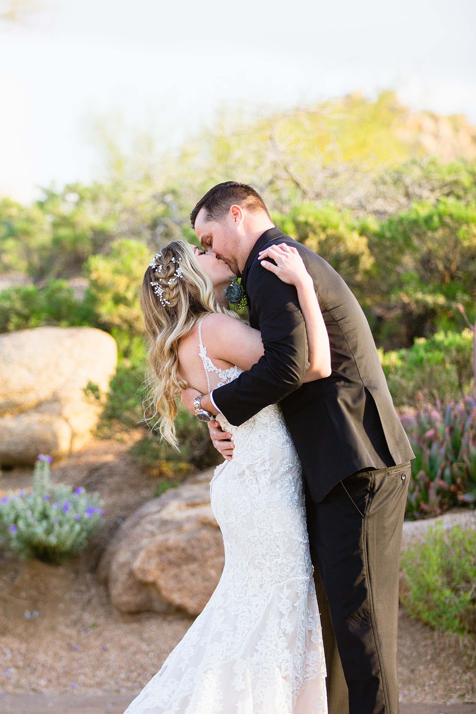 Bride and groom share their first kiss during their wedding ceremony at Troon North by Arizona wedding photographer PMA Photography.