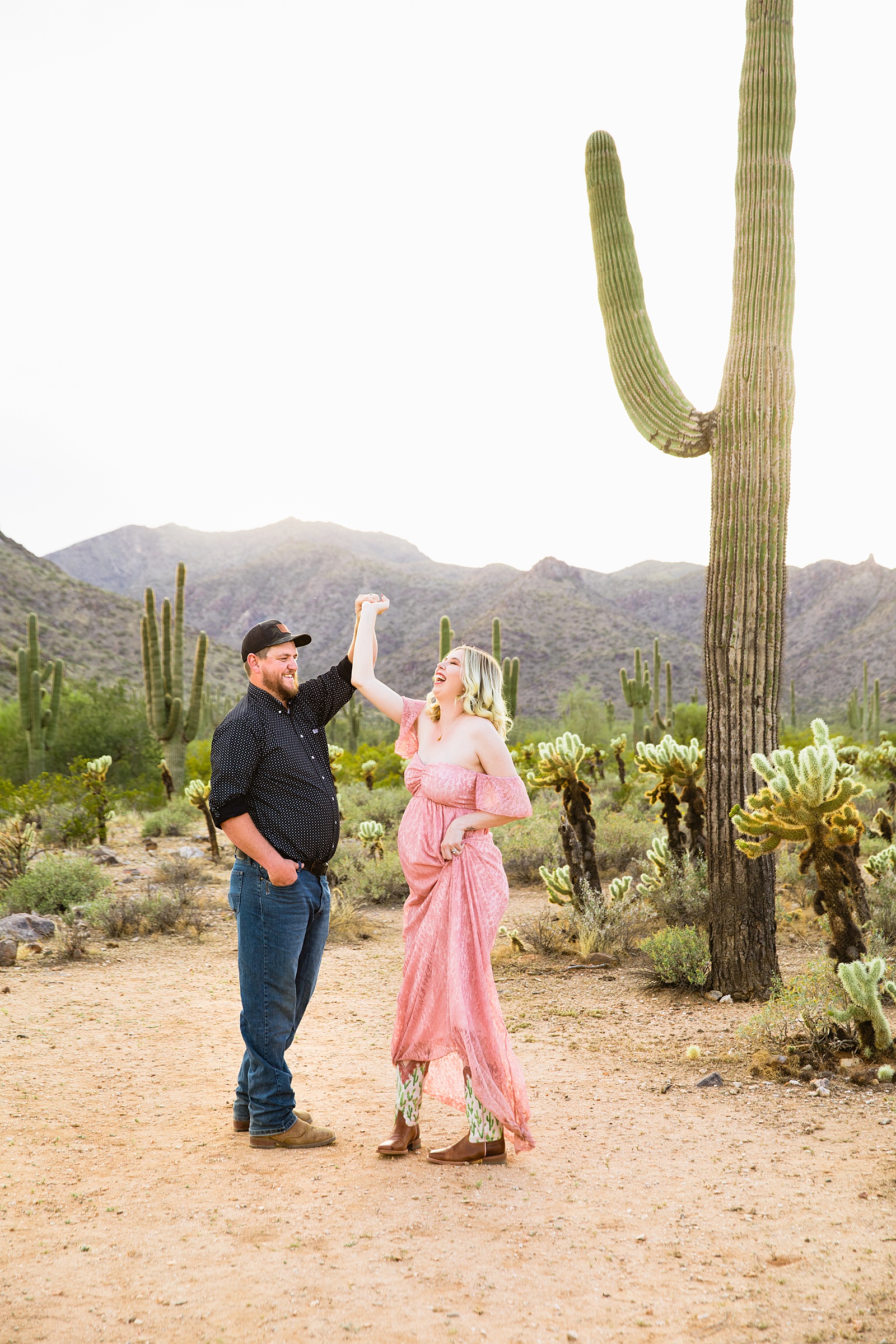 Couple laugh together during their White Tanks Desert maternity session by Phoenix maternity photographer PMA Photography.