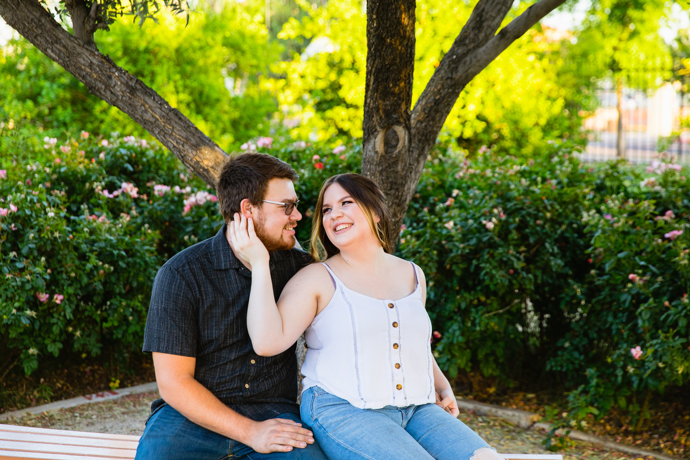 Couple look at each other during their Sahuaro Ranch engagement session by Glendale wedding photographer PMA Photography.