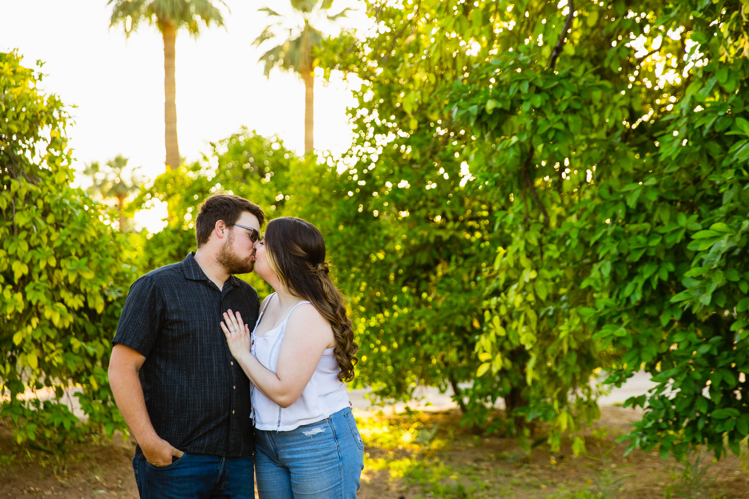 Couple share a kiss during their Glendale engagement session by Arizona wedding photographer PMA Photography.