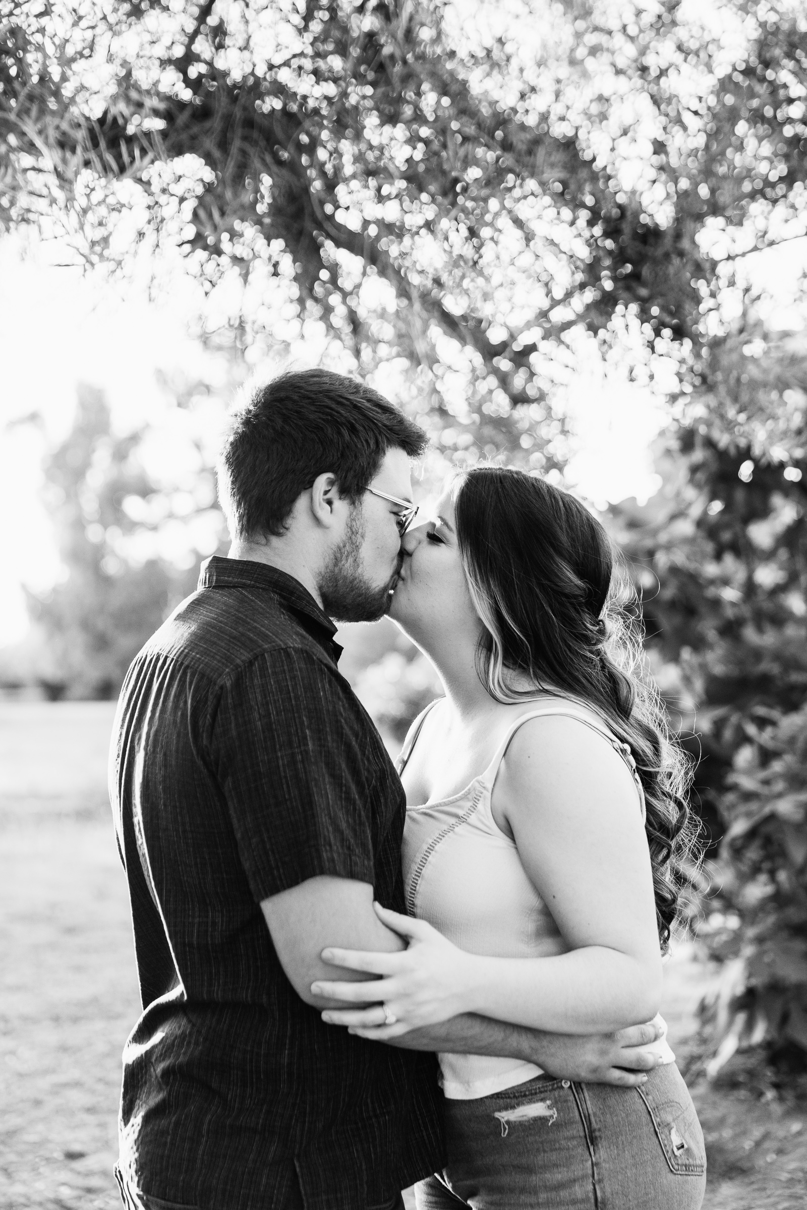 Couple share a kiss during their Glendale engagement session by Arizona wedding photographer PMA Photography.