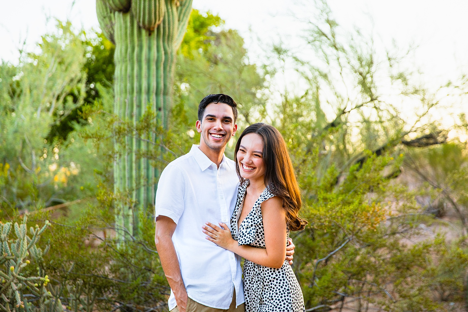 Couple laugh together during their Desert Botanical Garden engagement session by Phoenix engagement photographer PMA Photography.