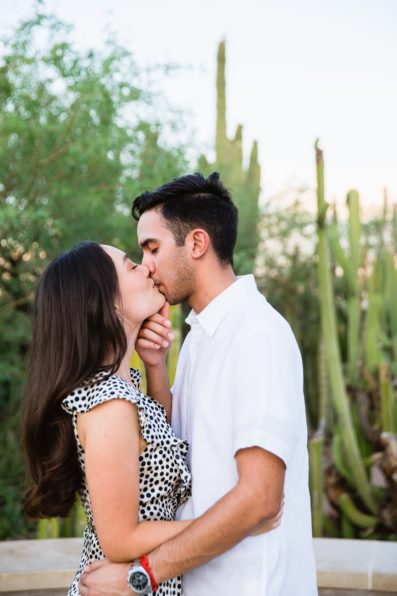Couple share a kiss during their Phoenix engagement session by Arizona wedding photographer PMA Photography.